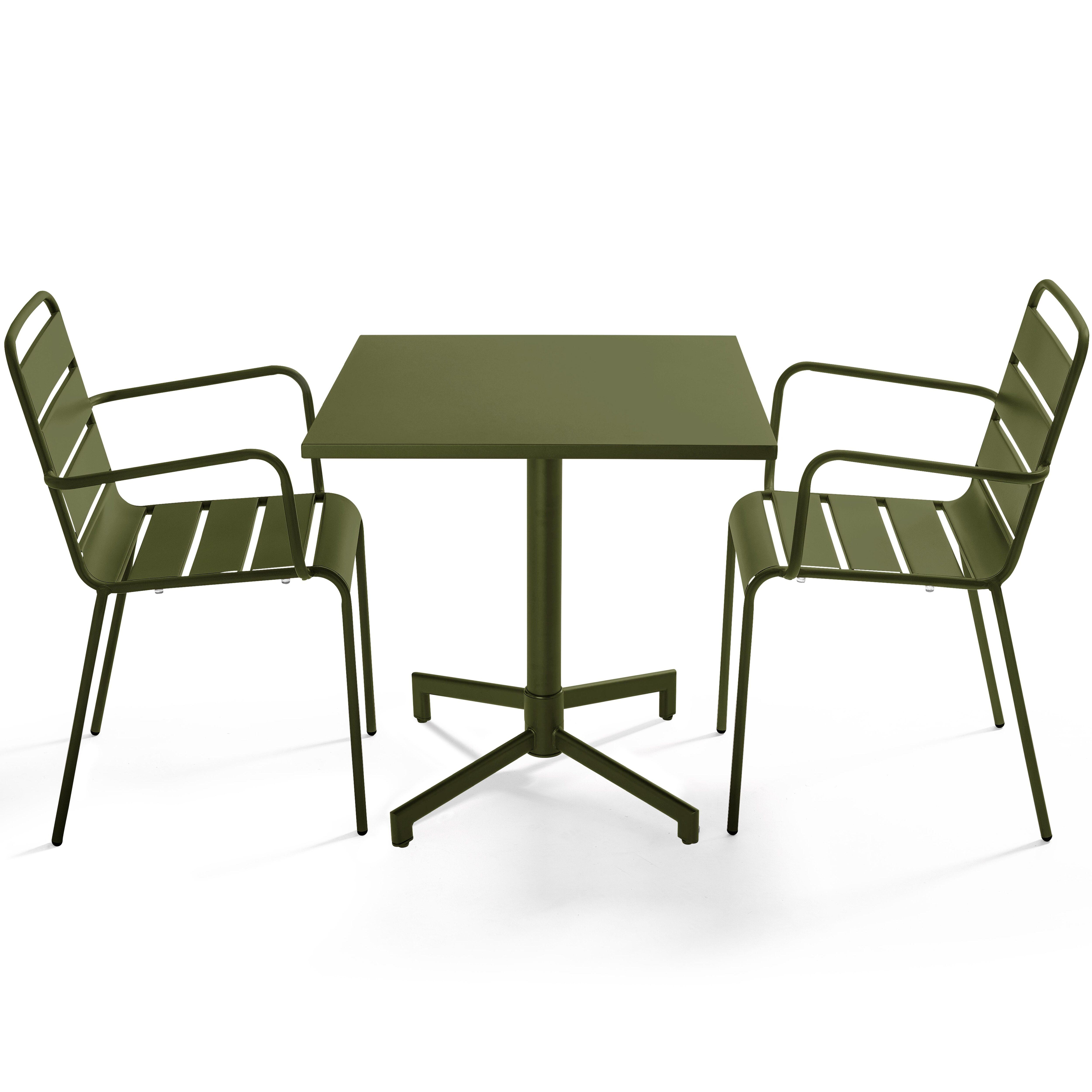 Ein grüner Tisch und zwei Stühle. Der Tisch ist quadratisch. Stühle haben Armlehnen und horizontale Latten.