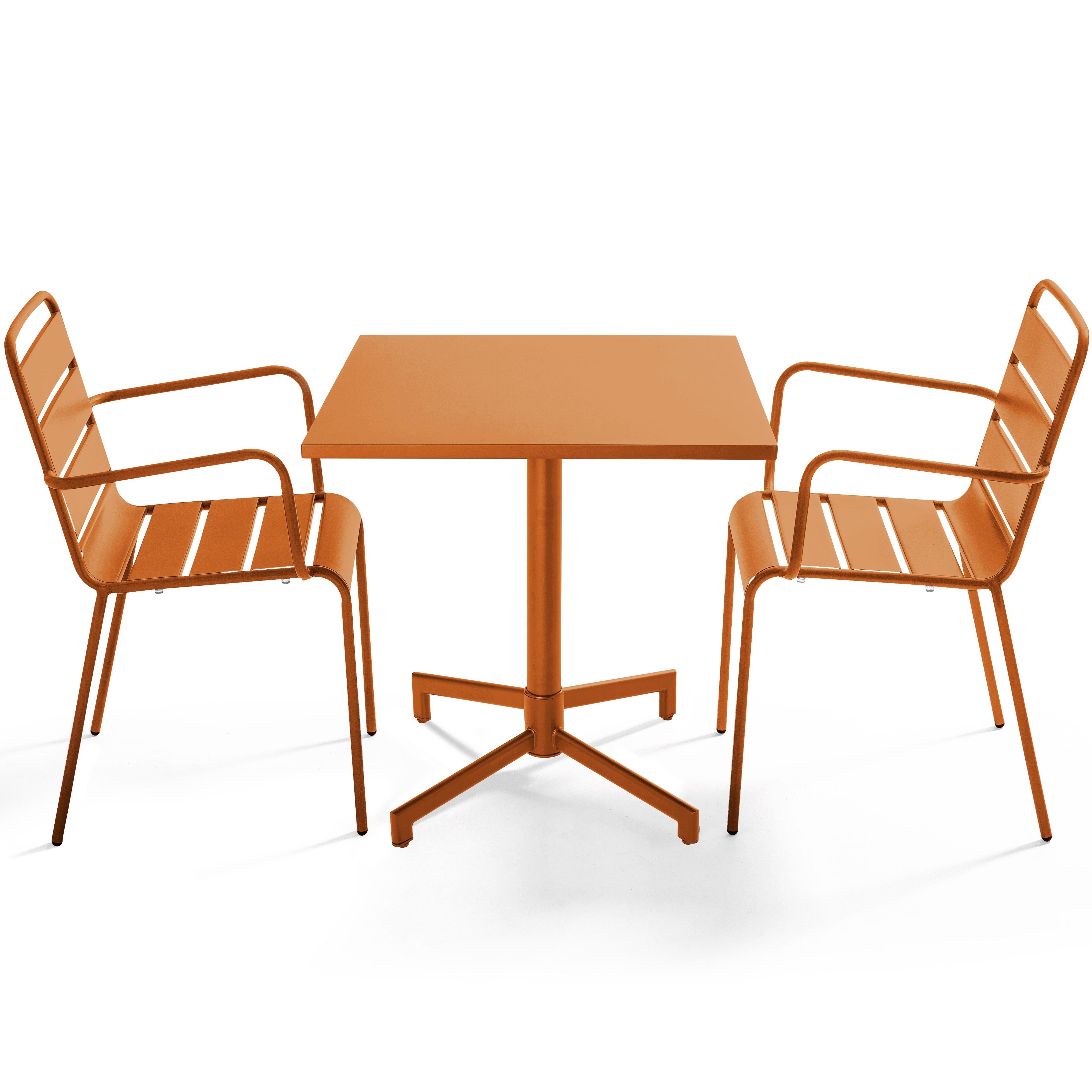 Ein orangefarbener Tisch mit zwei Stühlen. Alle sind aus Metall. Der Hintergrund ist weiß.