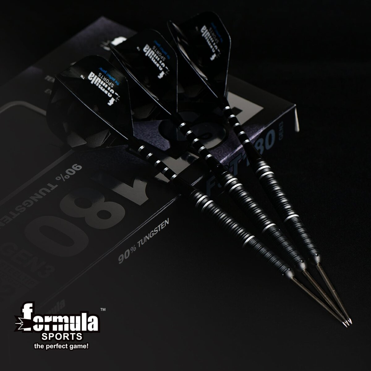 Vier schwarze Darts mit silbernen Streifen, angeordnet auf einer Schachtel. Die Darts haben schwarze Flights mit weißem Text.