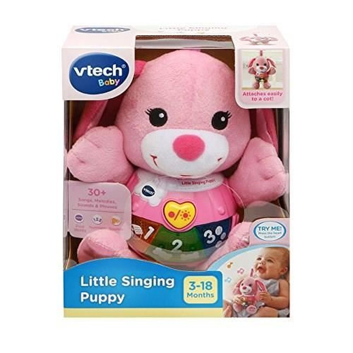 Ein pinkfarbenes VTech Little Singing Puppy-Spielzeug in einer Schachtel. Es hat Knöpfe und eine Herzform. Die Schachtel zeigt ein Baby mit dem Spielzeug.