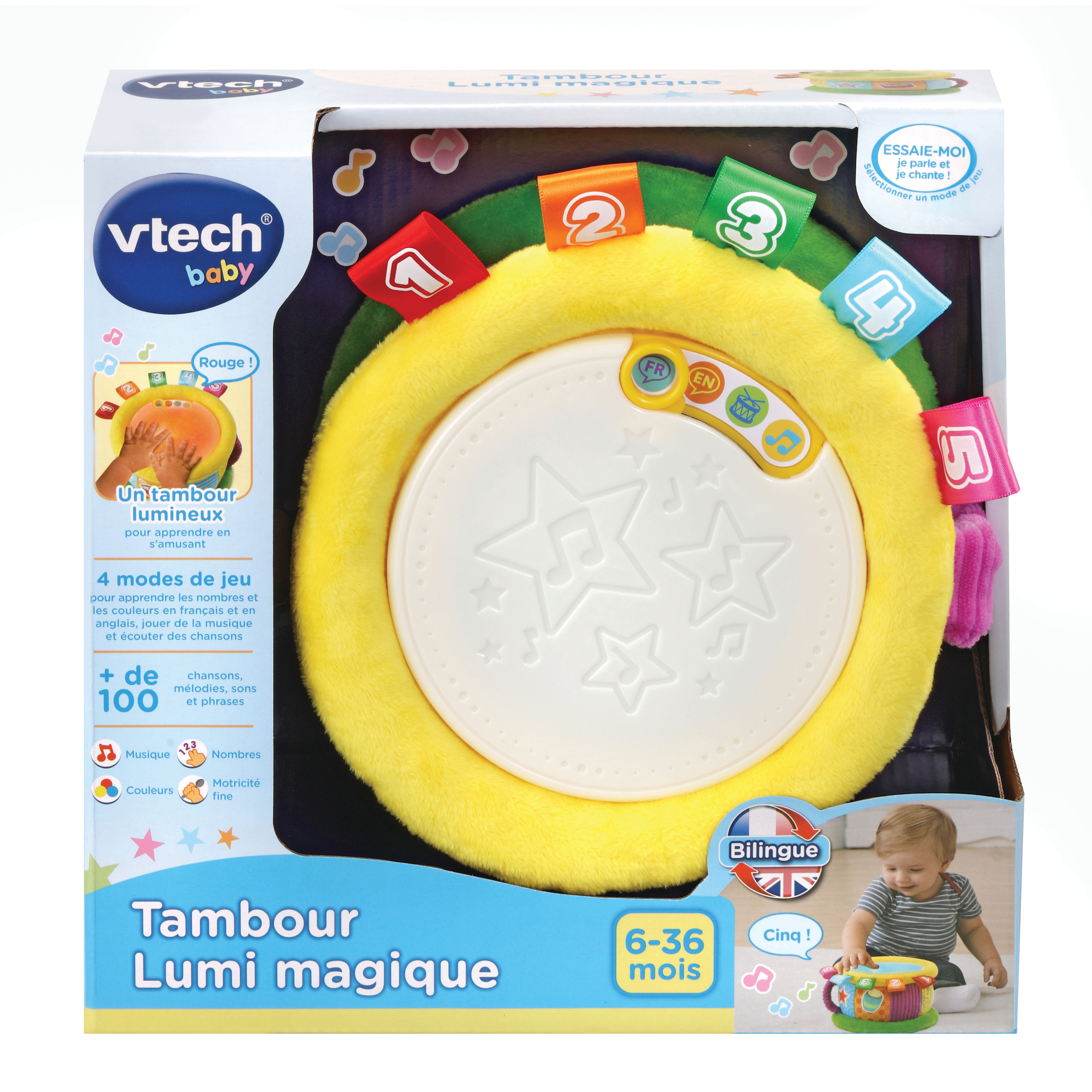 Eine gelbe Spielzeugtrommel mit bunten Anhängern. Ein Baby spielt mit einem ähnlichen Spielzeug. Text auf der Schachtel.