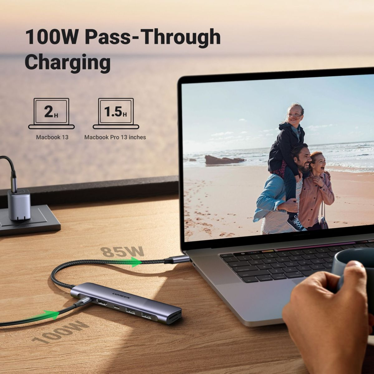 Ein Laptop ist mit einem Hub verbunden. Der Bildschirm zeigt eine Familie am Strand. Text zeigt 100W-Aufladung an.