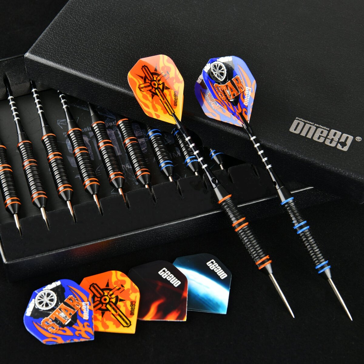 Dart-Set mit schwarzen, orangen und blauen Darts. Darts in einer schwarzen Box mit Ersatz-Flights darunter. Die Box hat ein 'one80'-Logo.