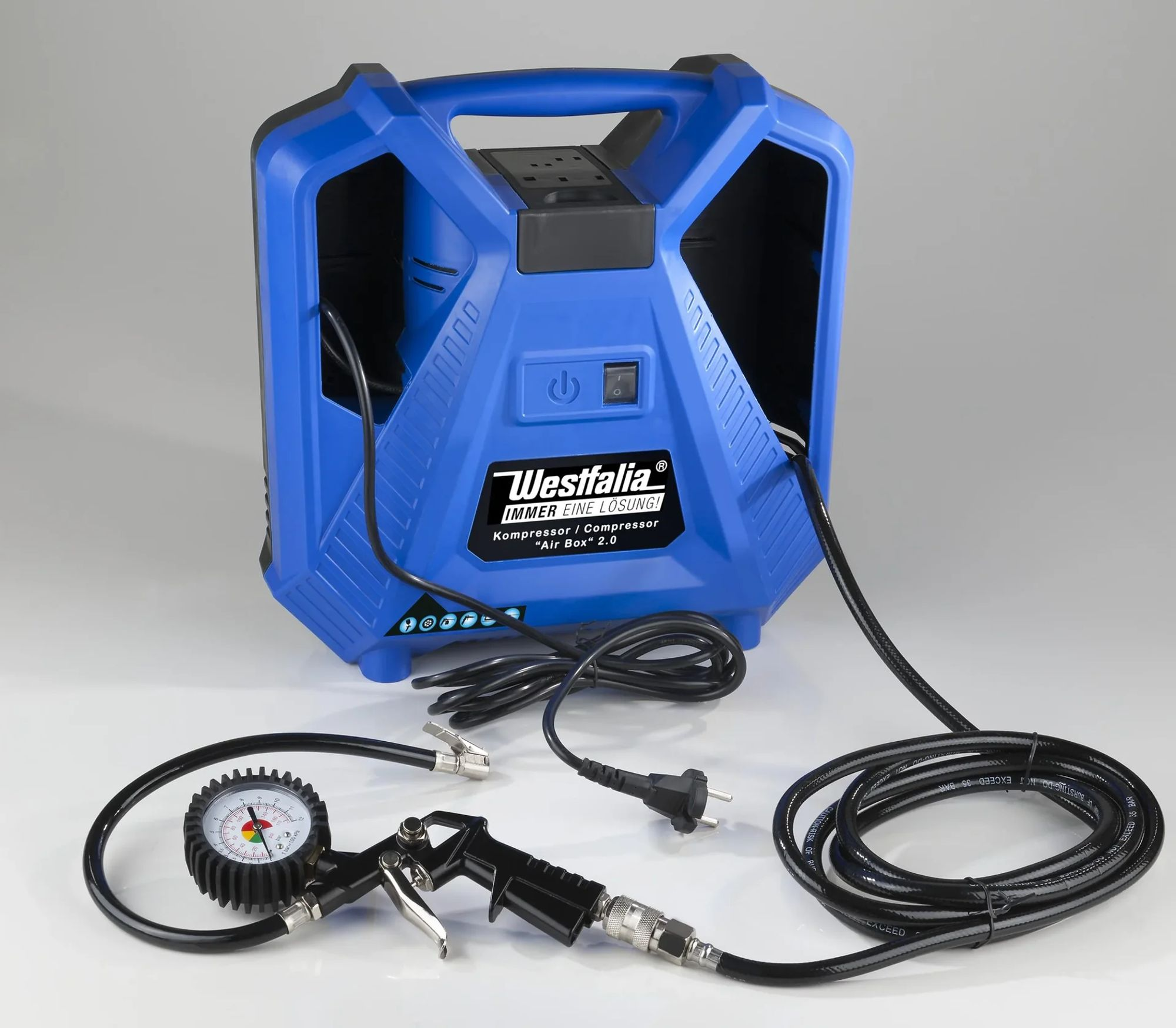 Blauer Westfalia-Luftkompressor mit Manometer, Düse und Netzkabel auf weißer Oberfläche. Der Kompressor hat einen Griff.