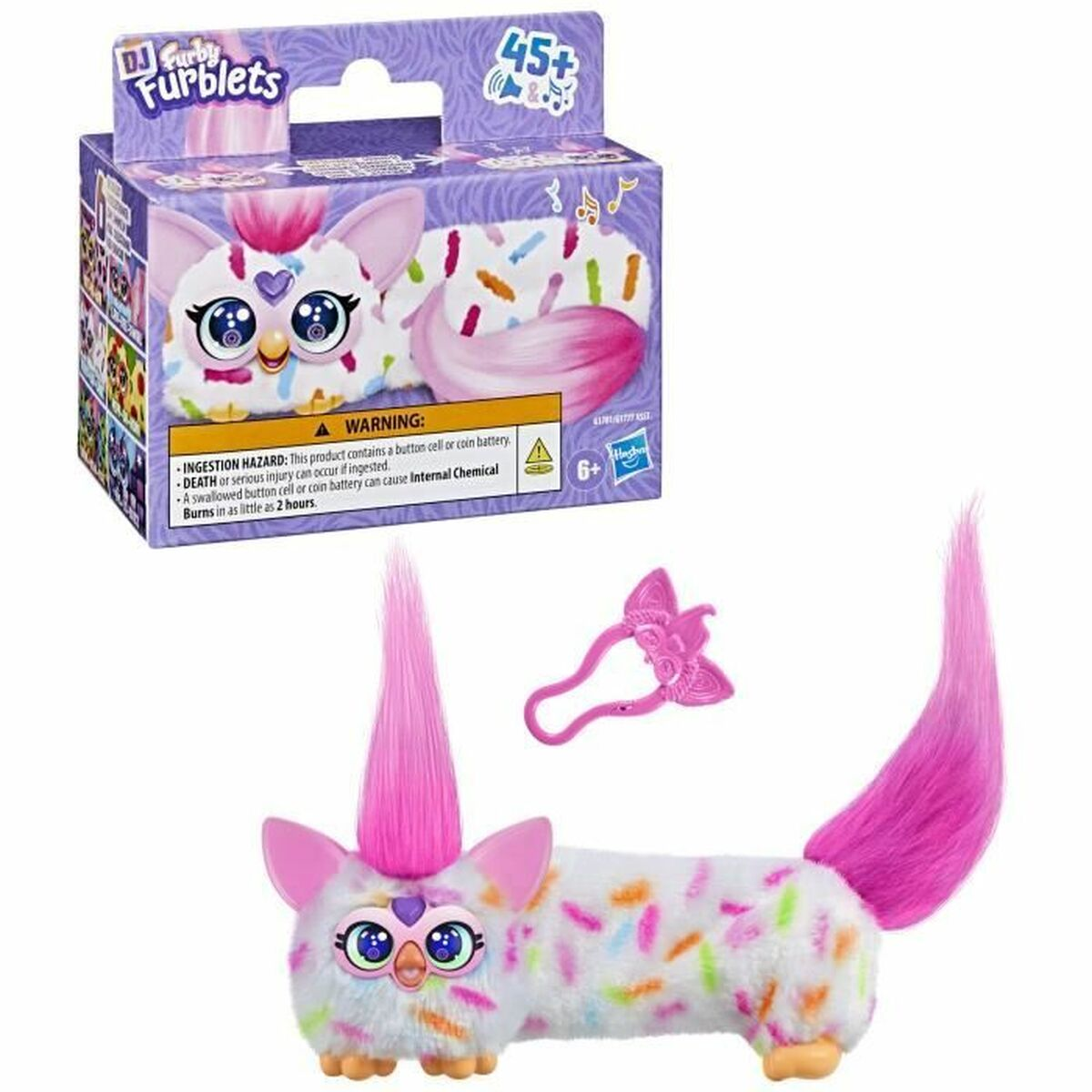 Ein Furblets-Spielzeug mit rosa Haaren, Schwanz und Ohren. Es hat einen weißen Körper mit bunten Streuseln und befindet sich neben seiner Schachtel und einem rosa Zubehör.
