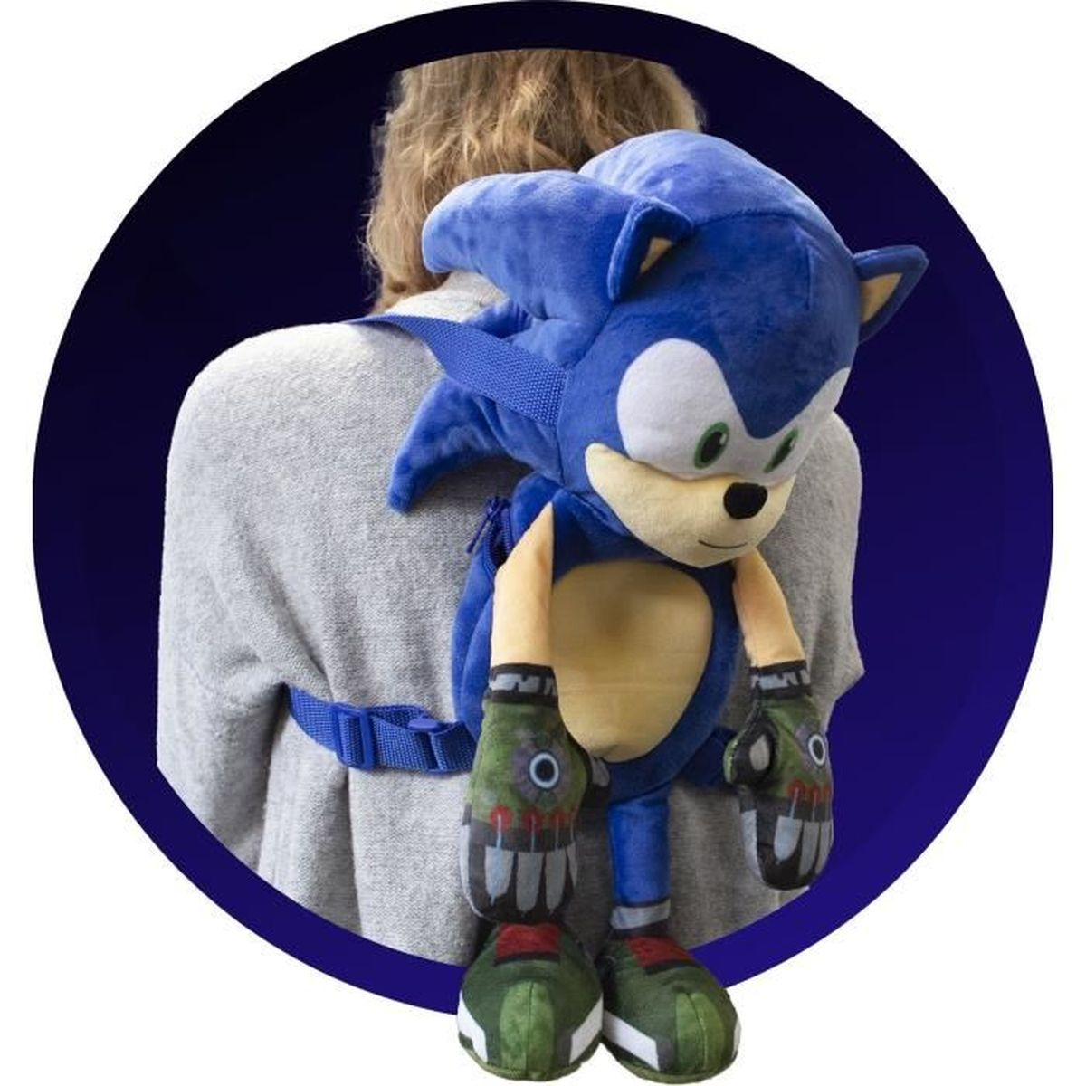 Una persona lleva una mochila azul de Sonic el Erizo. La mochila es de peluche y tiene la cara del personaje. El fondo es azul oscuro.