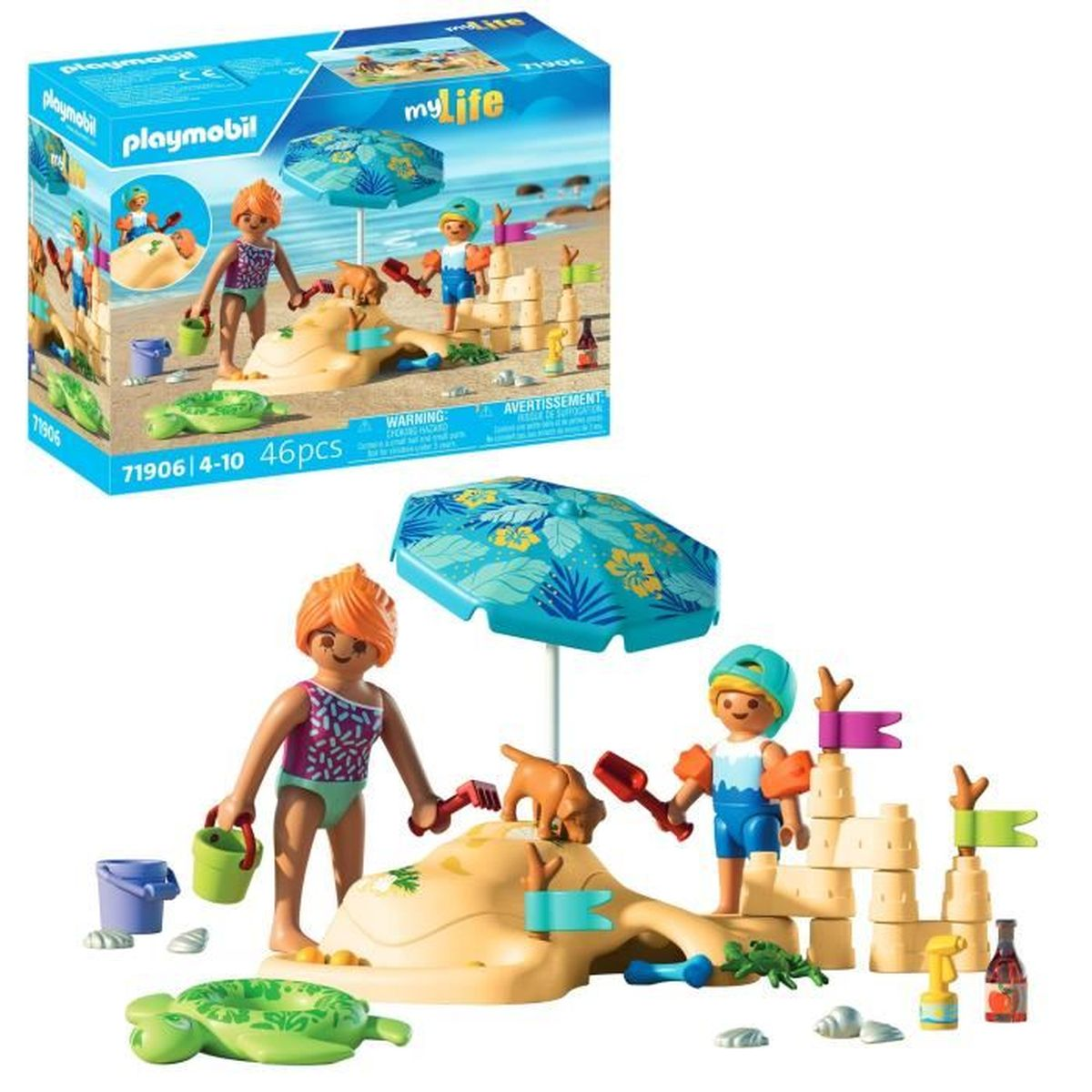 Un set da spiaggia Playmobil. Personaggi che giocano su un castello di sabbia, con un cane, un ombrellone e accessori. Una scatola sullo sfondo.