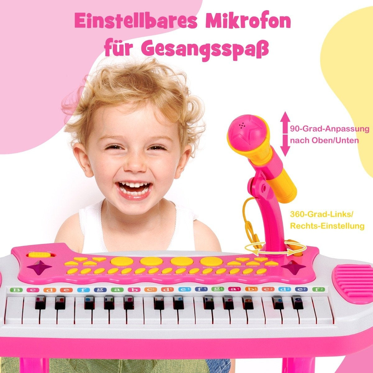 Un niño sonriente toca un teclado de juguete rosa con un micrófono. El teclado tiene teclas y botones en blanco y negro.