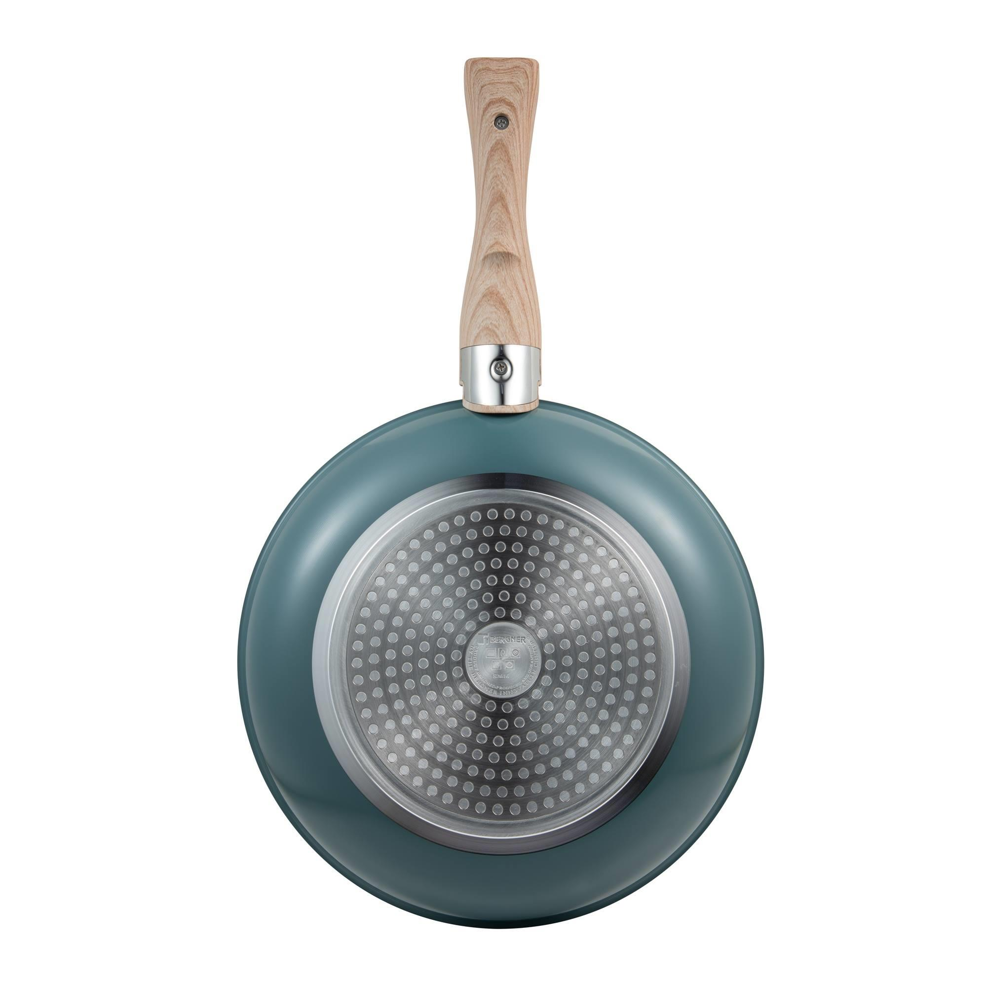 Una sartén wok turquesa con mango de madera sobre fondo blanco.