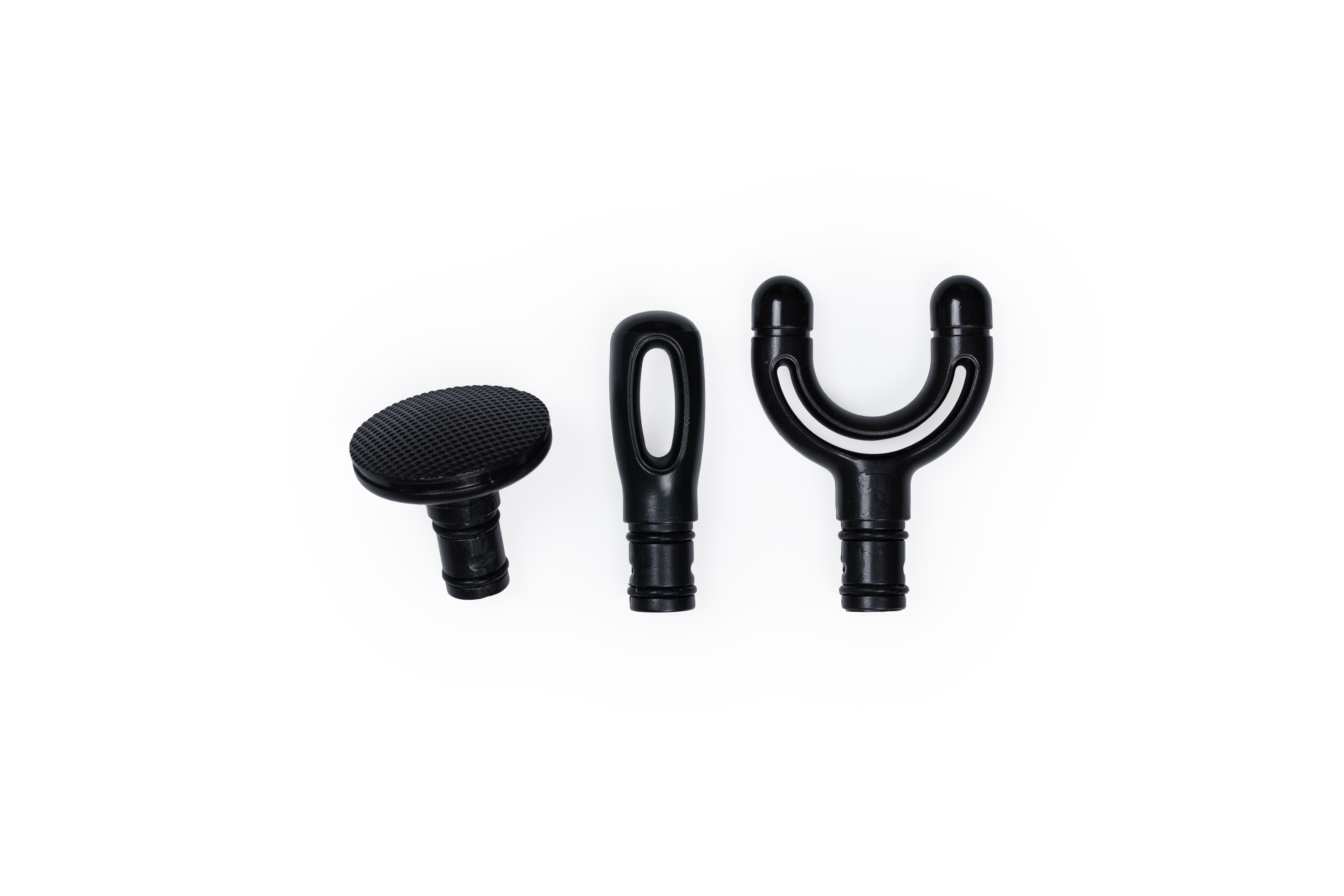 Trzy czarne nasadki do masażu na białym tle. Jedna okrągła, jedna długa i jedna w kształcie litery Y.