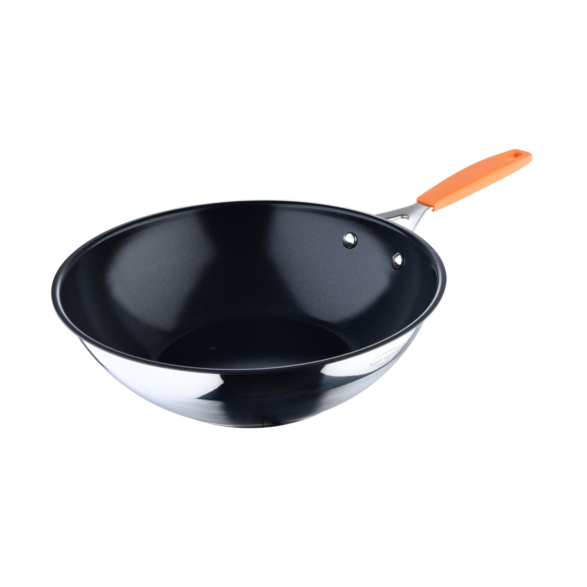 Una sartén wok con interior negro y mango naranja, aislado sobre fondo blanco.