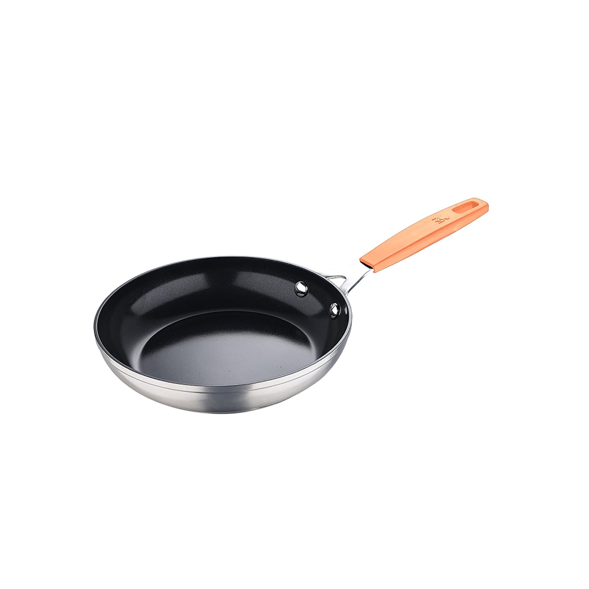 Una sartén antiadherente con interior negro y mango naranja. La sartén es plateada.