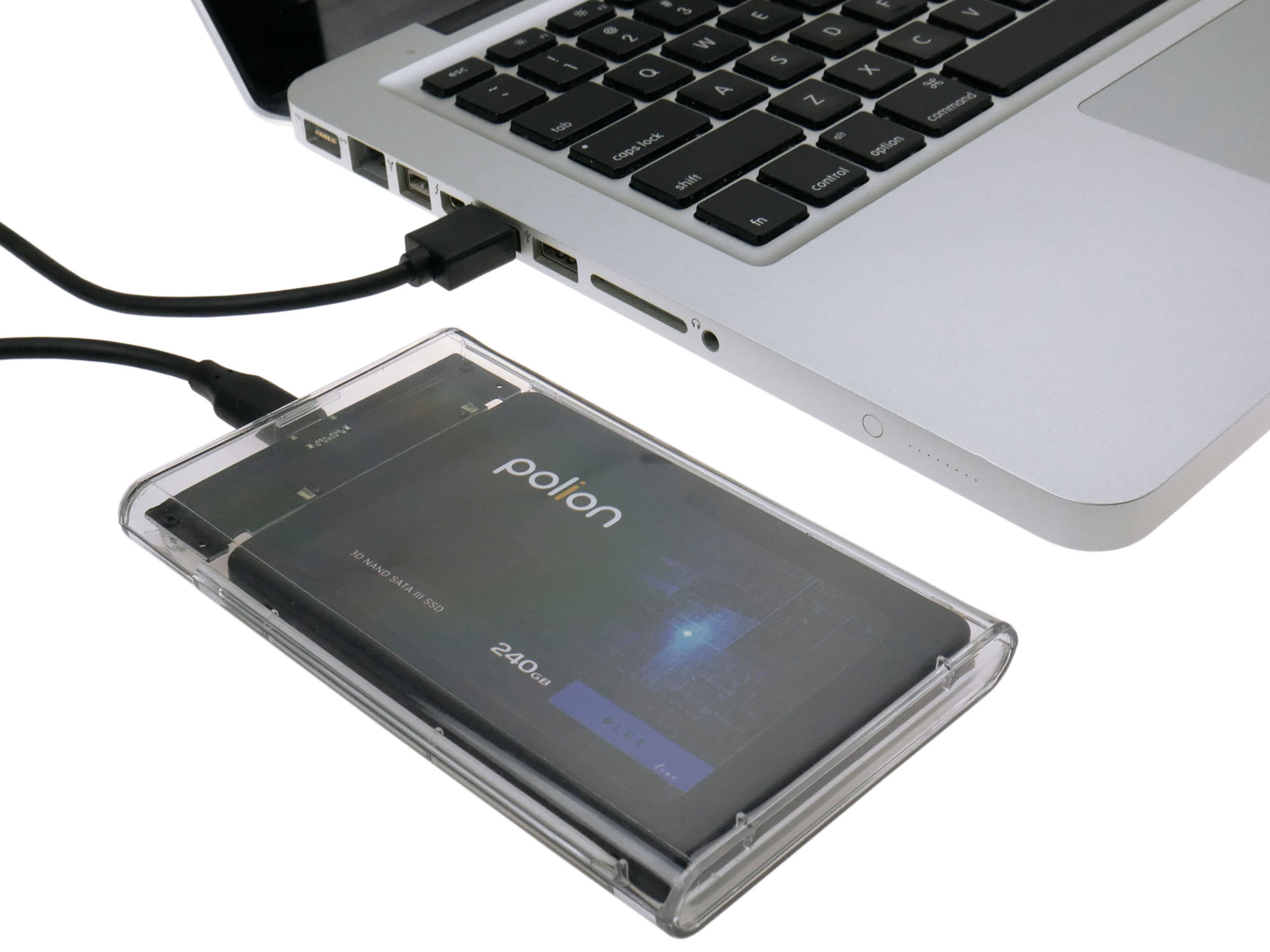 Laptop podłączony do zewnętrznego dysku twardego. Dysk twardy jest w przezroczystej obudowie. Widoczna jest klawiatura laptopa.