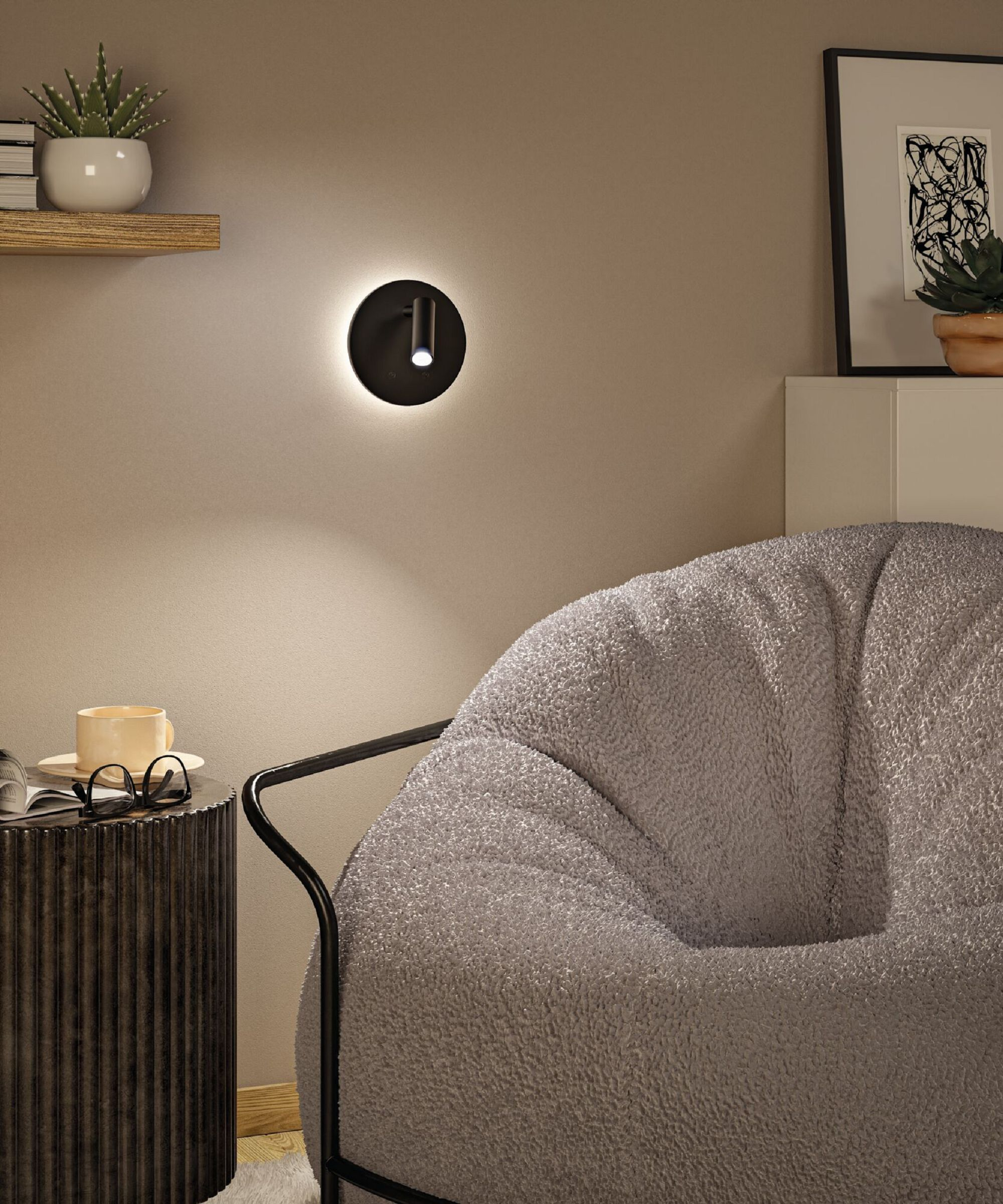 Pokój z szarą pufą, stolikiem z kawą, szklankami i lampą ścienną.