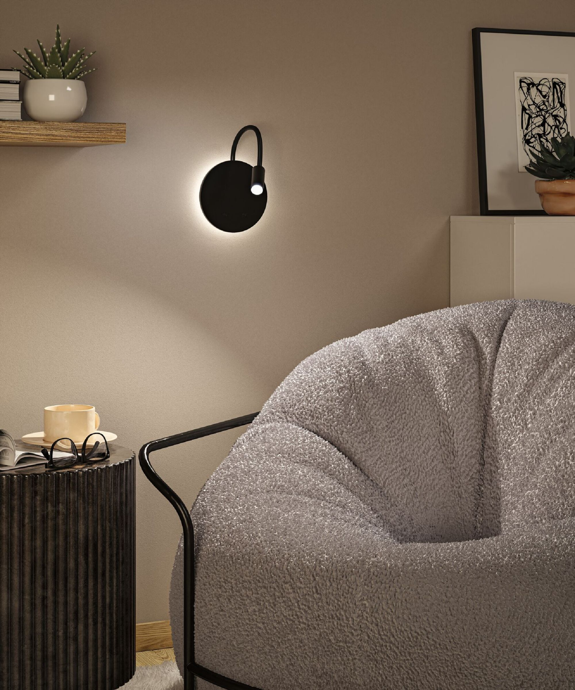 Nowoczesny salon z szarym fotelem, czarną lampą ścienną, małym stolikiem i oprawionym dziełem sztuki.