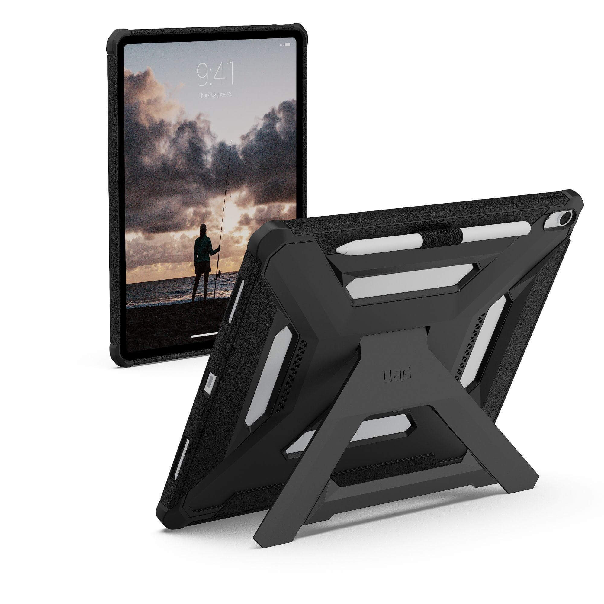 Czarny tablet z etui ochronnym. Ekran wyświetla osobę łowiącą ryby o zachodzie słońca. Stojak podtrzymuje tablet.