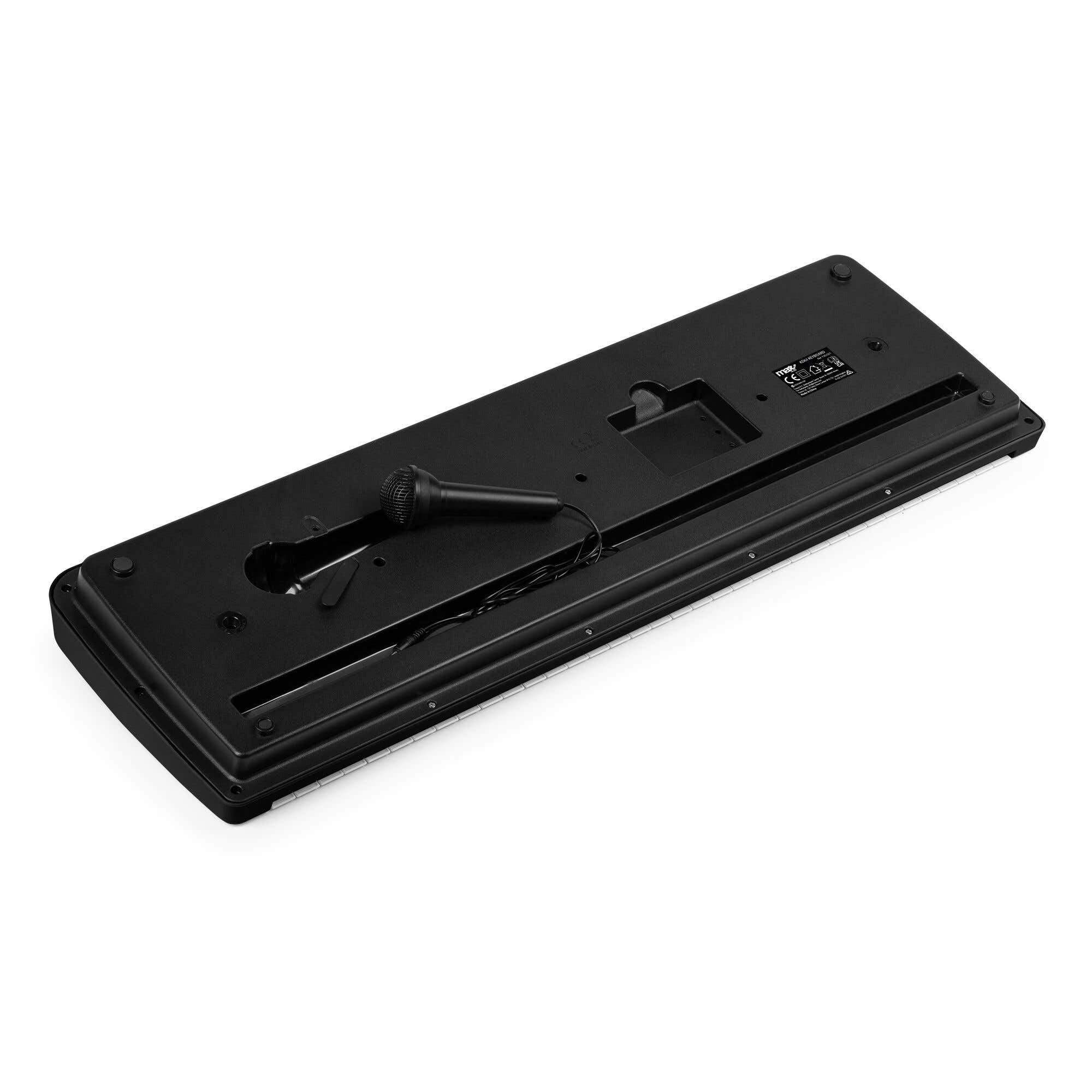 Teclado negro con micrófono. Las teclas son blancas. El teclado está sobre una superficie blanca.