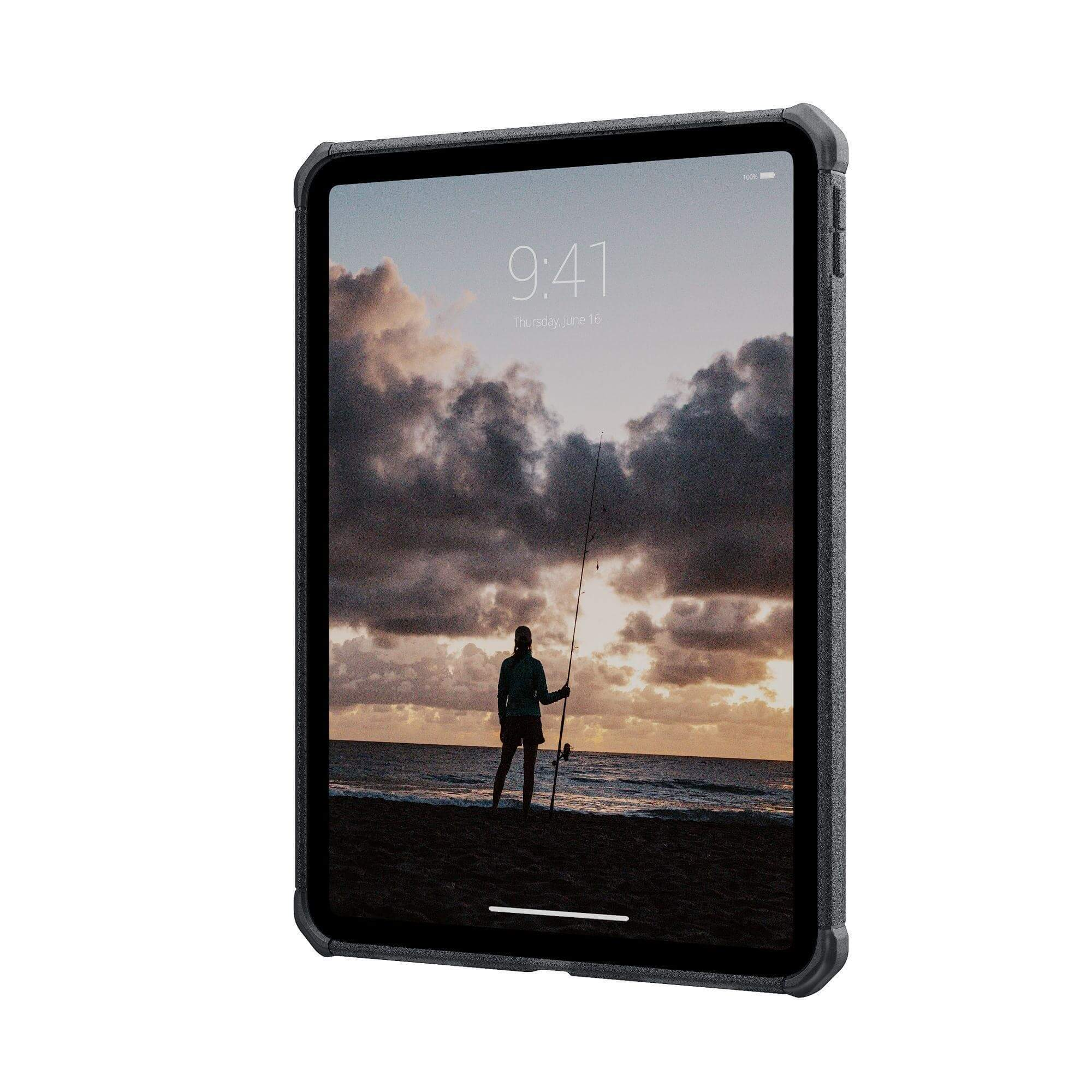 Tablet z widokiem na plażę z osobą trzymającą wędkę o zachodzie słońca.