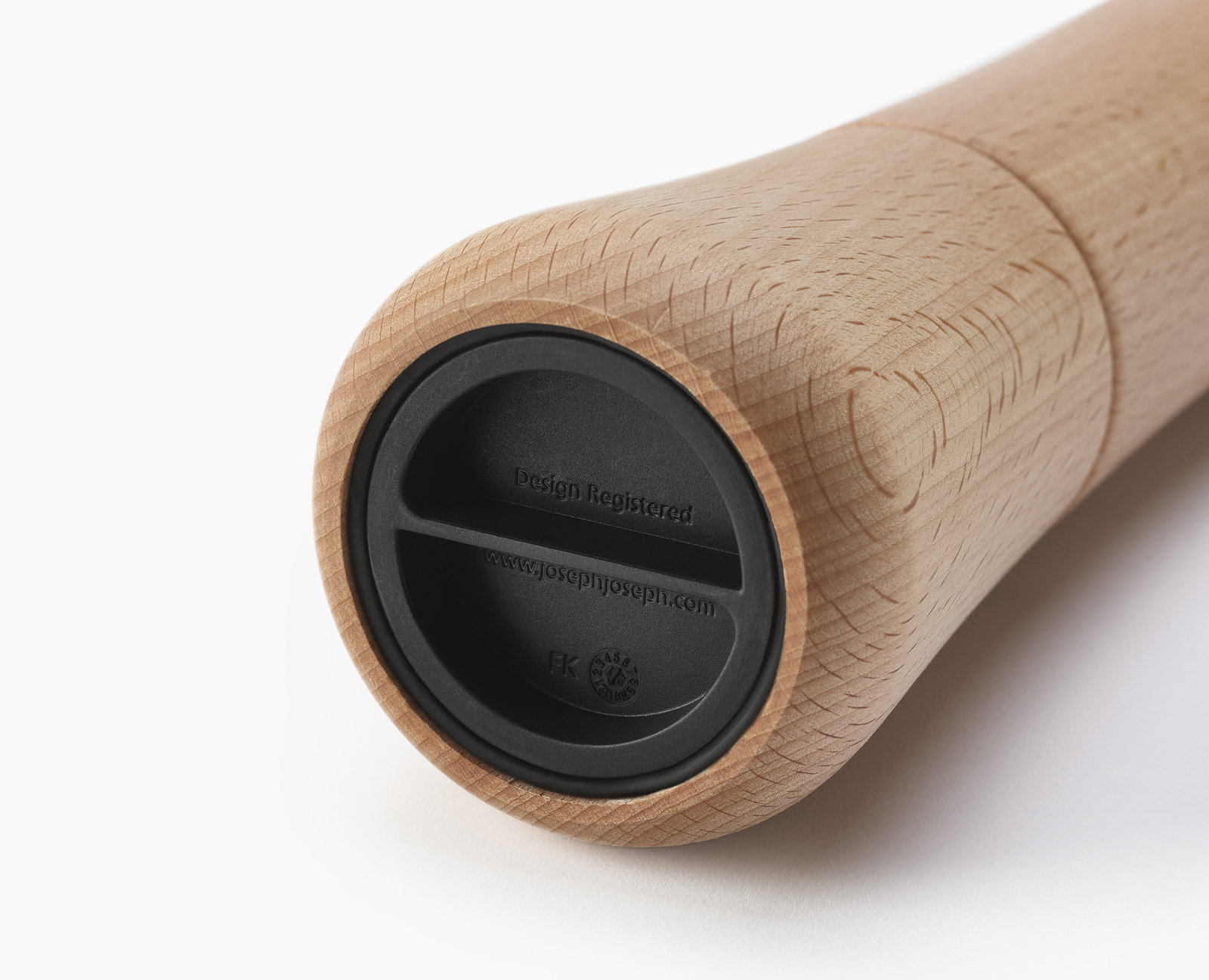 Molinillo de pimienta de madera con base negra. La base tiene el texto "Design Registered" y "www.josephjoseph.com".