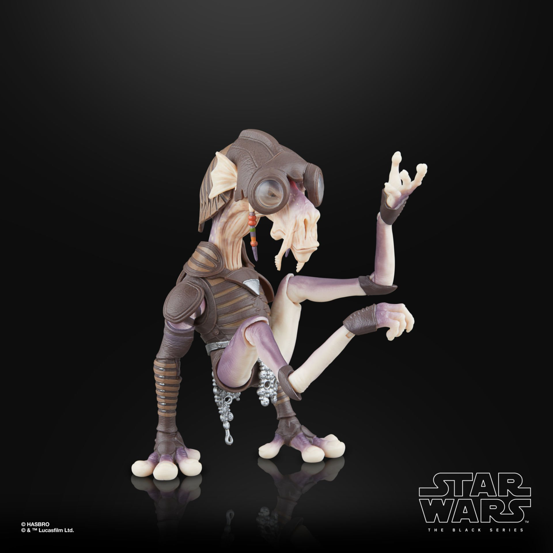 Bir Star Wars figürü. Kahverengi zırhı ve açık renk bir vücudu var. Siyah bir arka plan üzerinde. Figür bir el hareketi yapıyor.