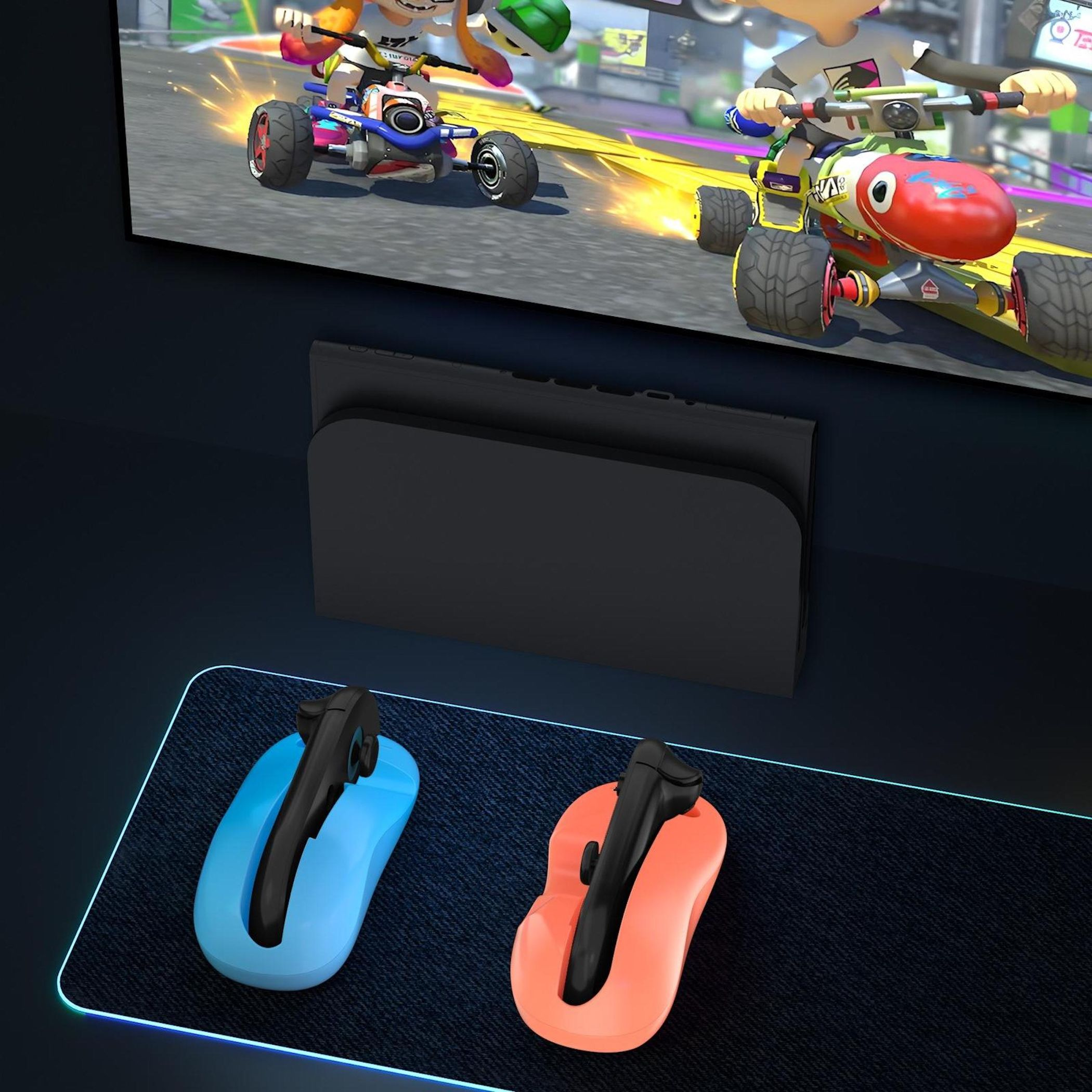 Una configuración de consola de juegos con una pantalla que muestra una carrera de karts y controladores en una base azul y naranja.