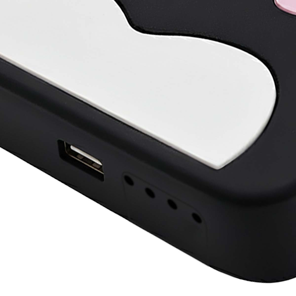 Gros plan sur une coque de téléphone noire et blanche avec un port USB et de petits trous. La coque a un motif blanc.