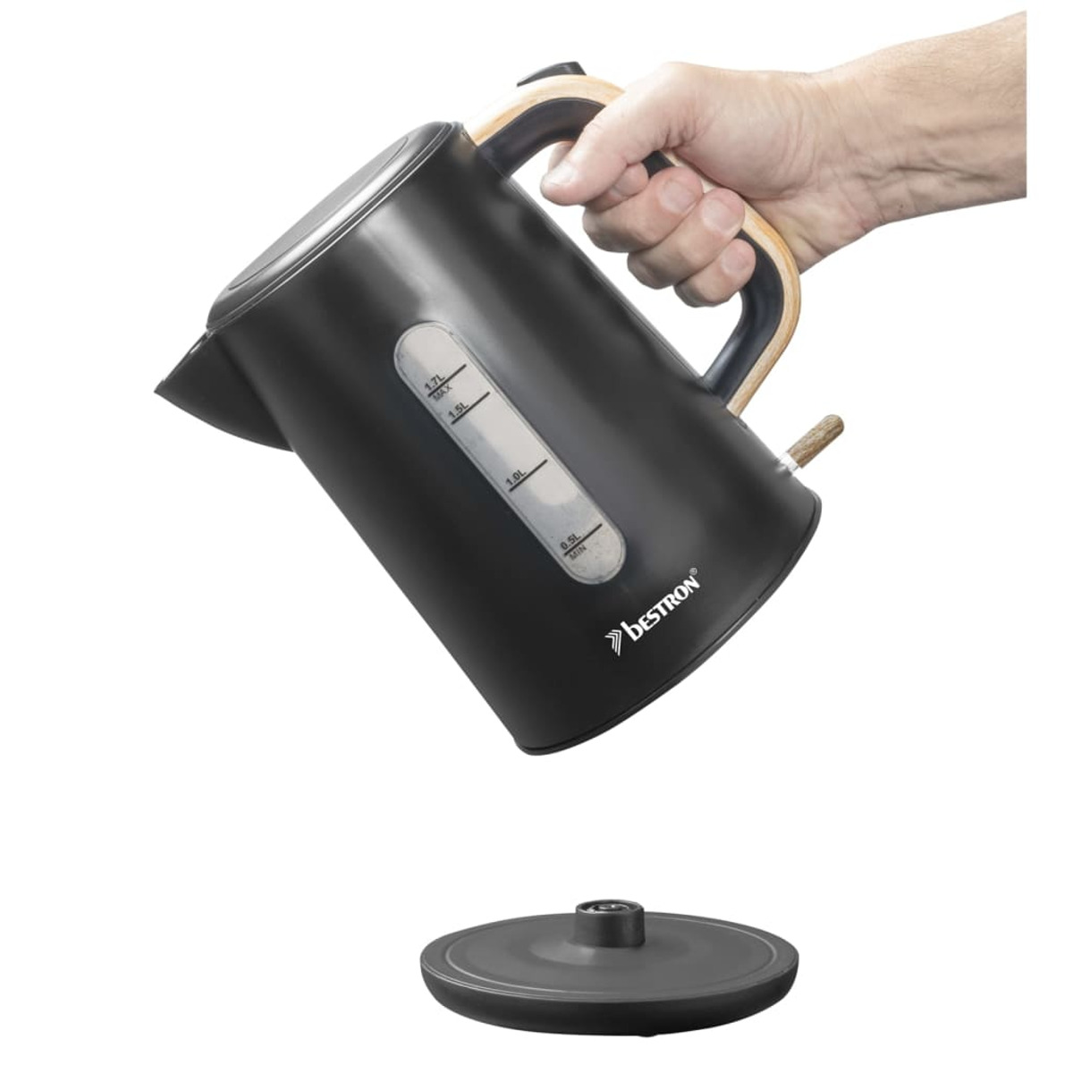 Un bollitore elettrico nero con manico in legno è tenuto da una mano. La base è sotto. Il bollitore ha un indicatore del livello dell'acqua.