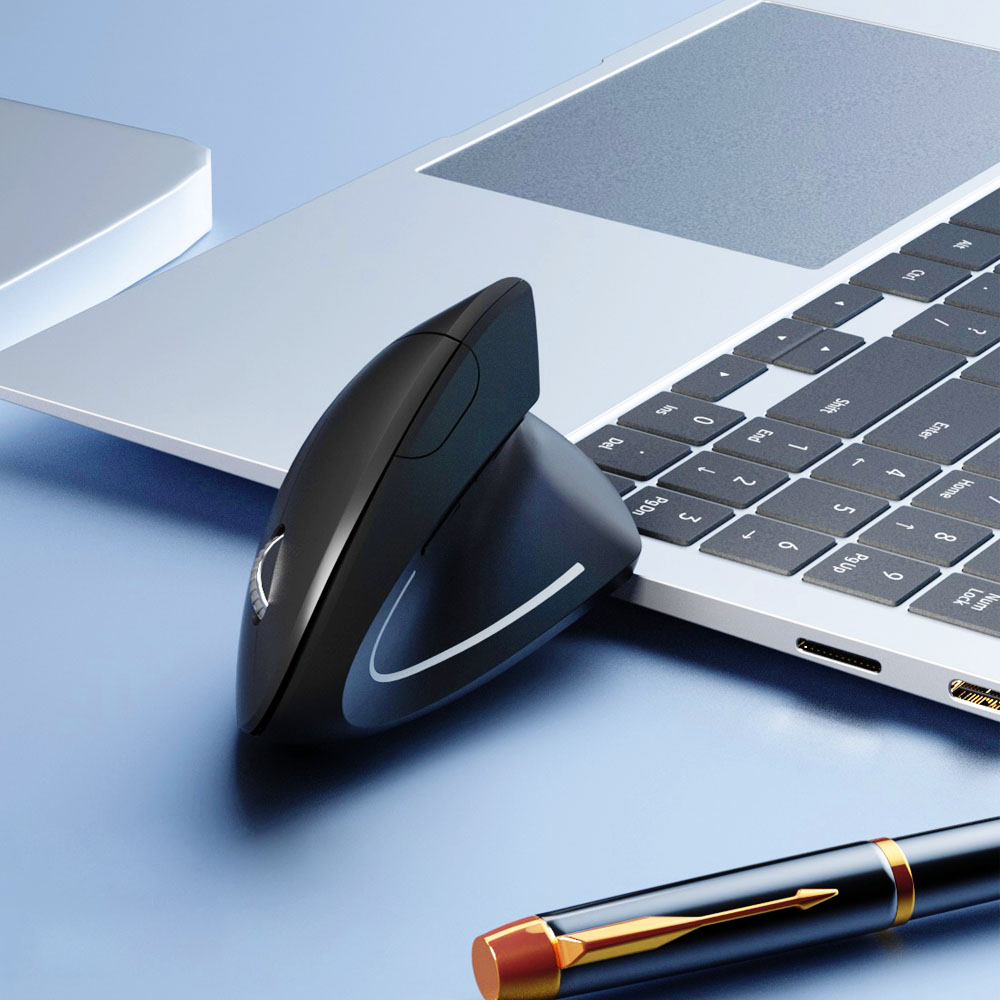 Czarna ergonomiczna mysz leży na klawiaturze laptopa. Poniżej długopis. Scena znajduje się na niebieskiej powierzchni.