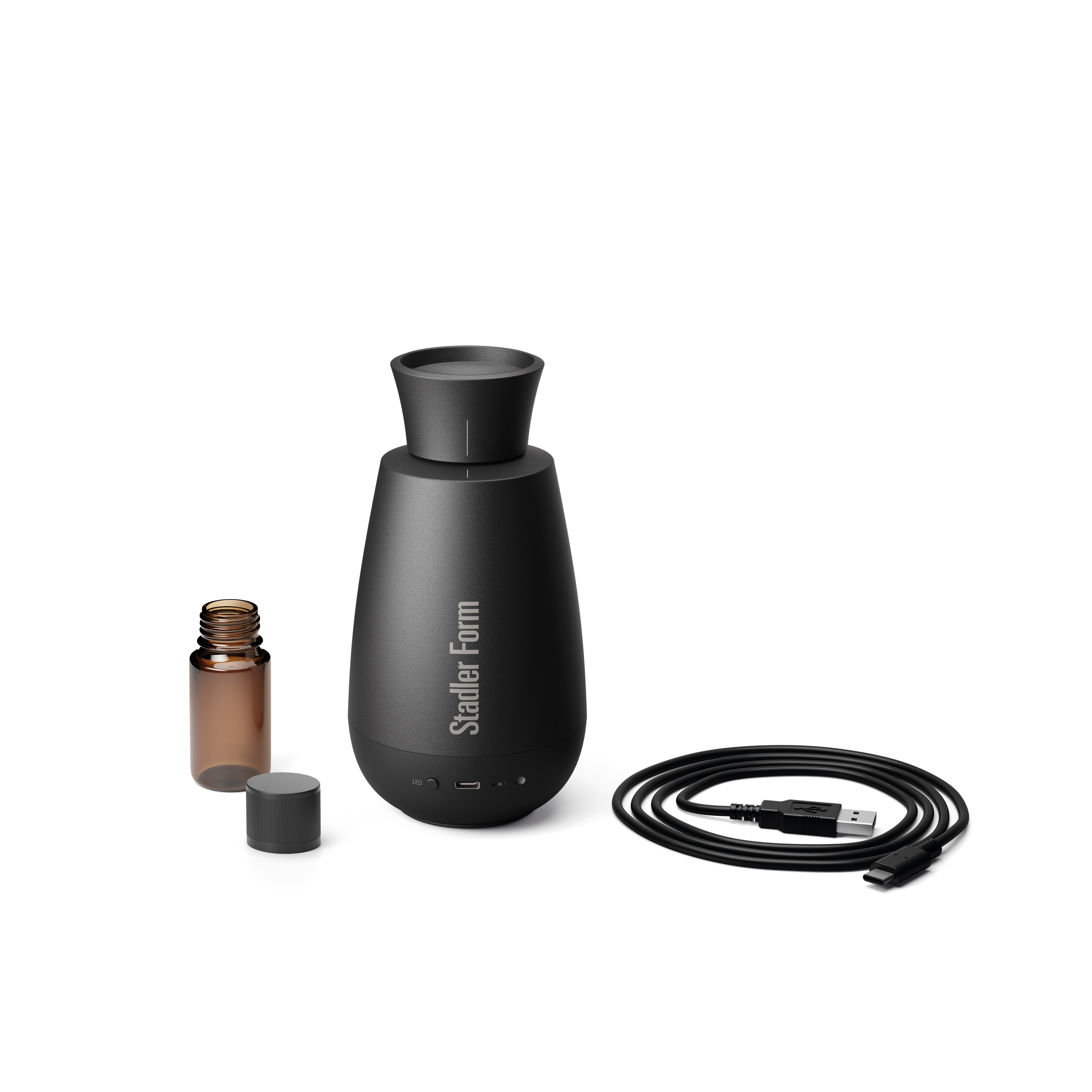 Black diffuser with accessories. Includes a small amber bottle, USB-C cable, and a black cap, all on a white background.