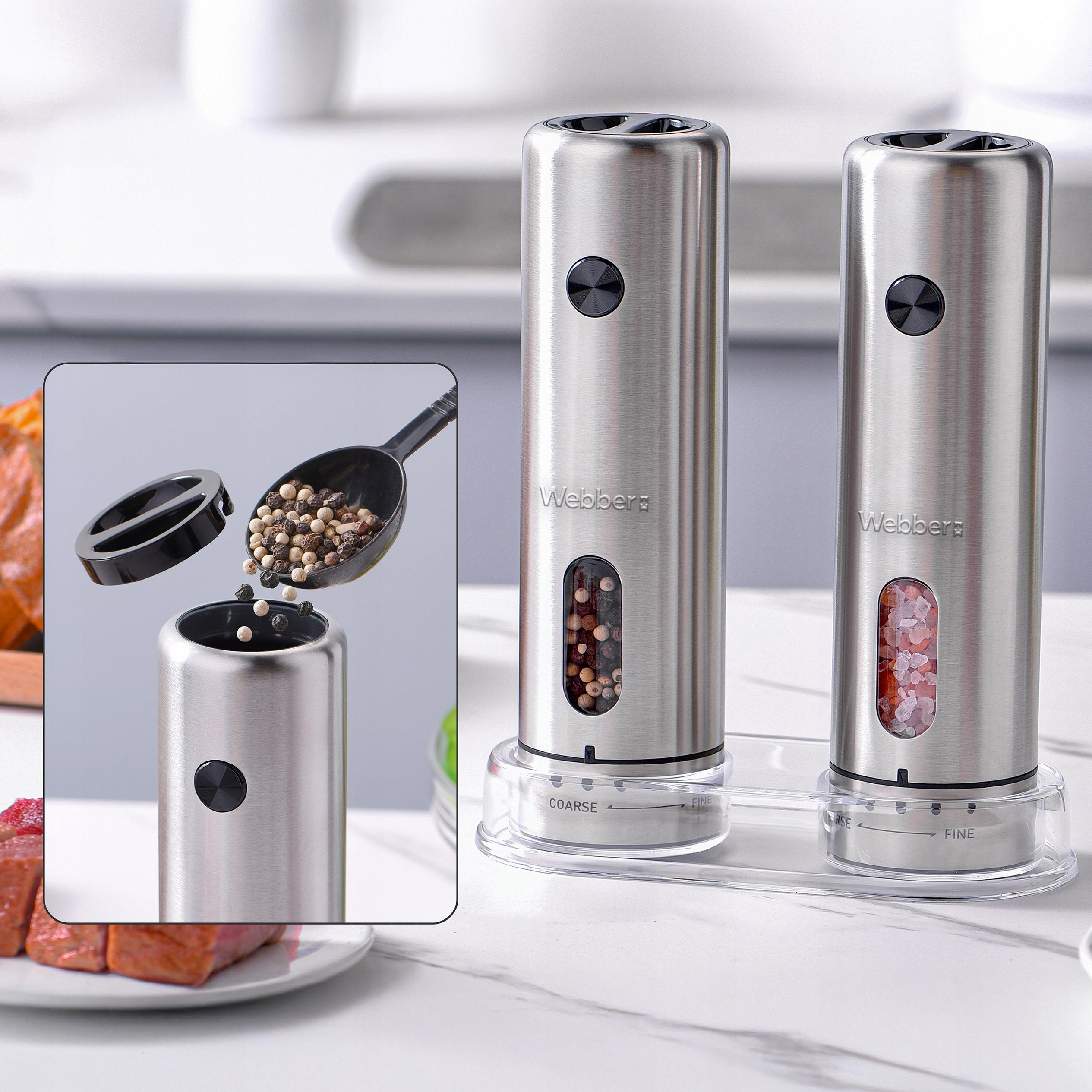 Młynki do soli i pieprzu ze stali nierdzewnej. Jeden jest napełniany. Mięso na talerzu na pierwszym planie.