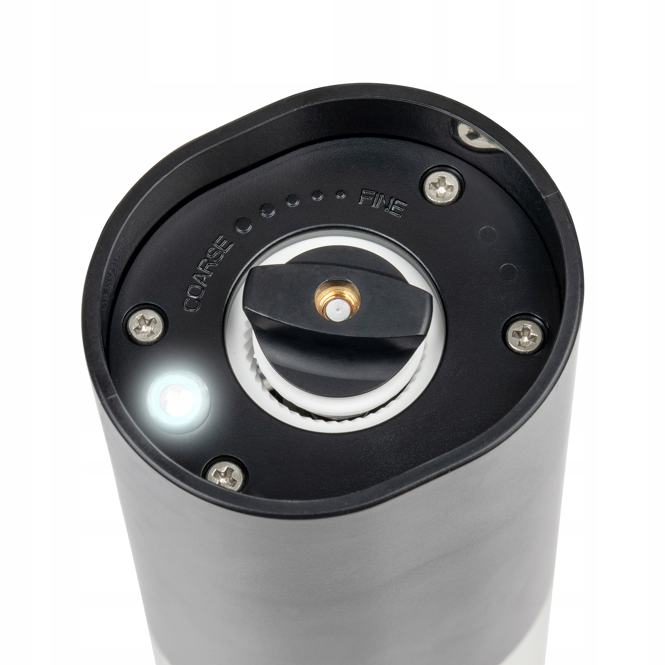 Zbliżenie na górę młynka do pieprzu. Czarny wierzch z ustawieniami grubości i drobności. Świeci światło.