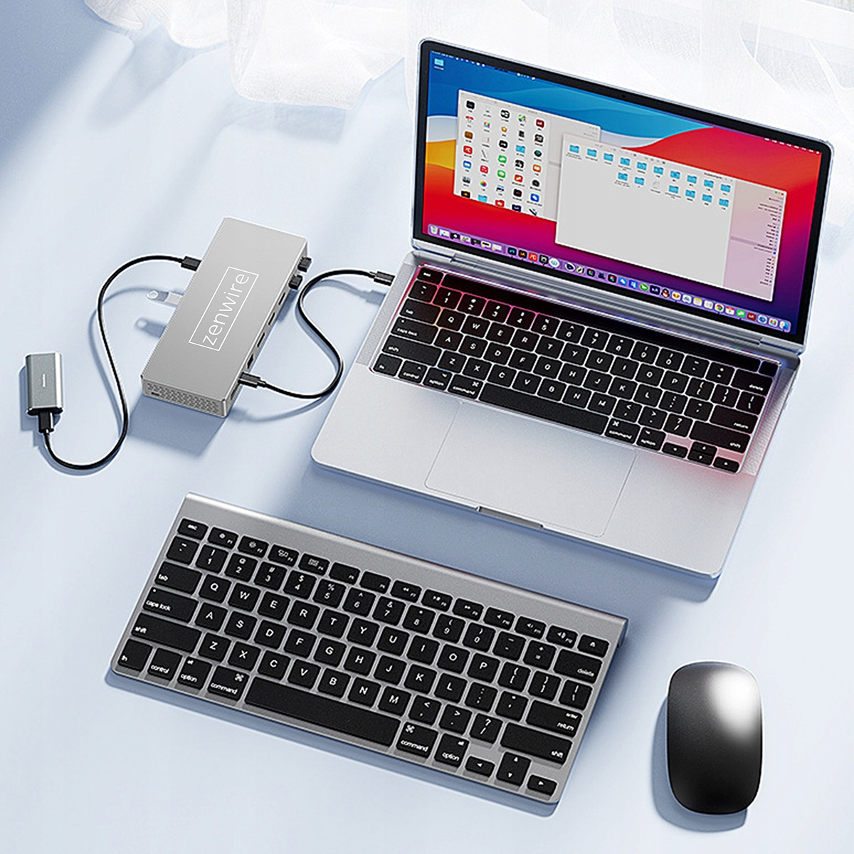 Laptop z klawiaturą i myszą. Hub Zenwire łączy się z laptopem. Klawiatura i mysz są srebrne i czarne.