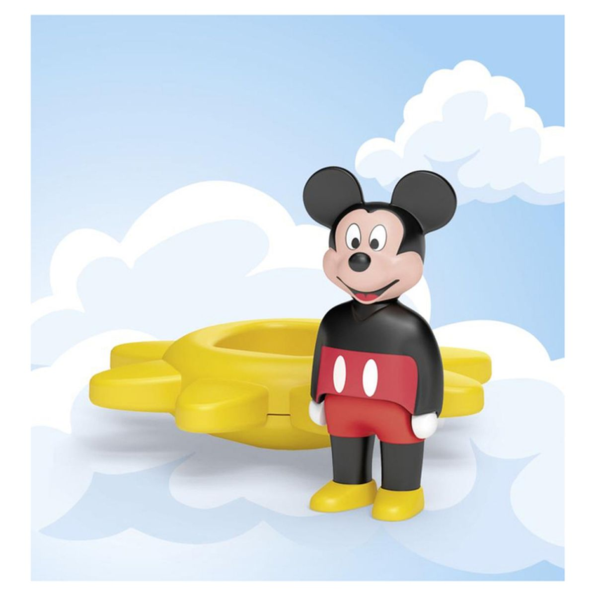 Figurka Myszki Miki stoi obok żółtej zabawki. Tło przedstawia chmury na jasnoniebieskim niebie.