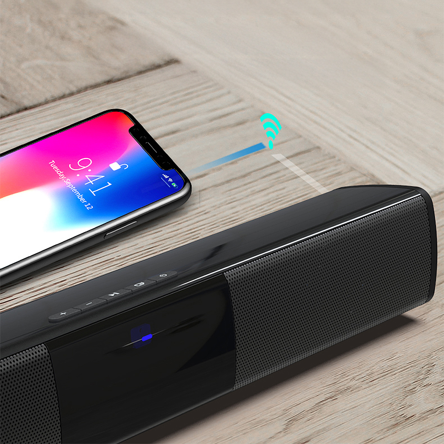 Uno smartphone si connette in modalità wireless a una soundbar nera. Lo schermo del telefono mostra l'ora. Sfondo in legno con un'icona wifi.