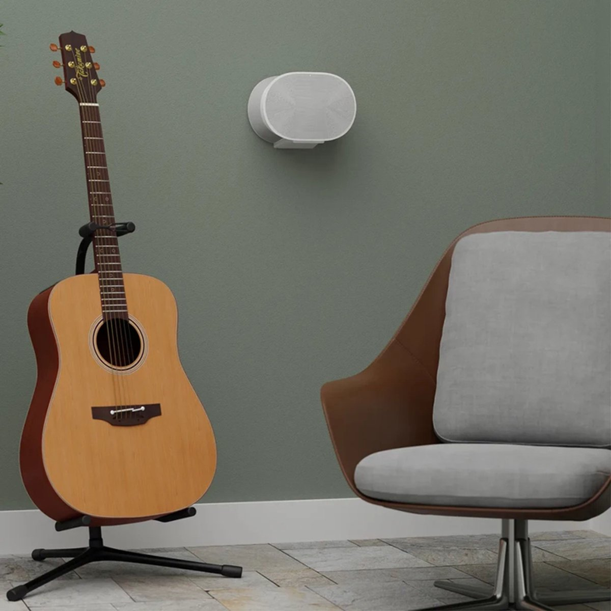 Acoustic guitar on a stand. A white speaker is mounted on the wall. A brown and gray chair is in the background.