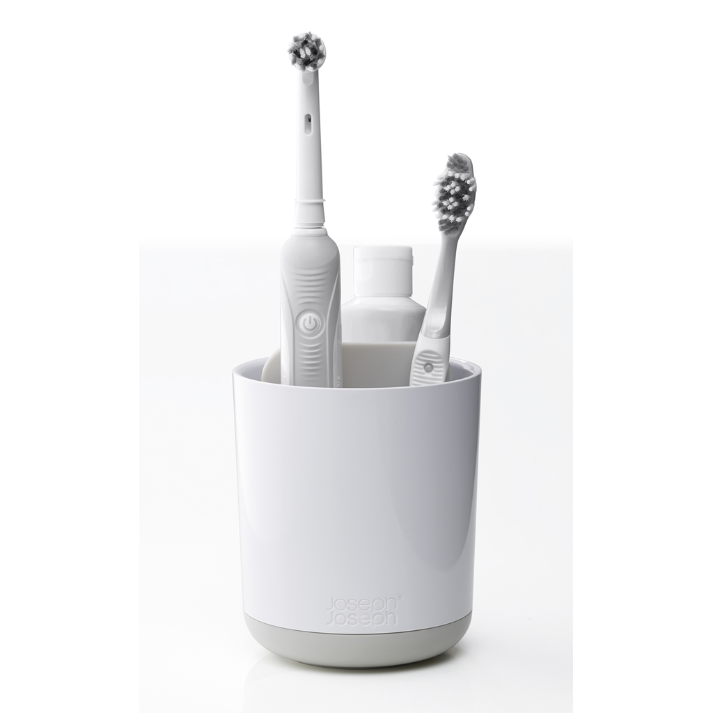 Un porta cepillos de dientes blanco con un cepillo eléctrico, un cepillo manual y una botella dentro. La base es gris.