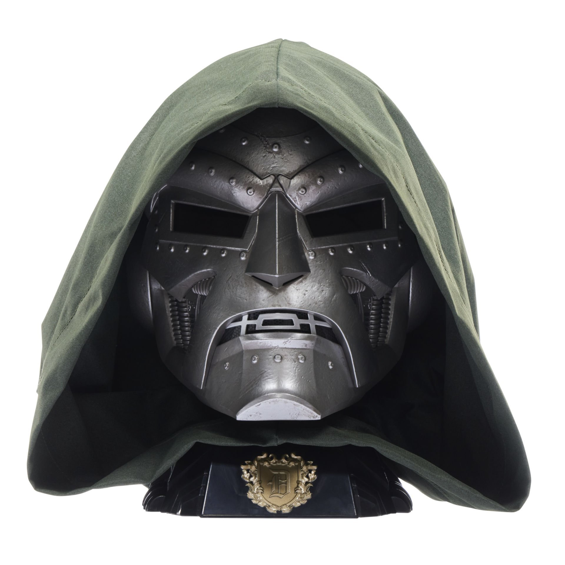 Yeşil başlığı olan metalik bir Doctor Doom maskesi. Maske sert bir yüze sahip ve altın bir amblemle siyah bir taban üzerinde duruyor.