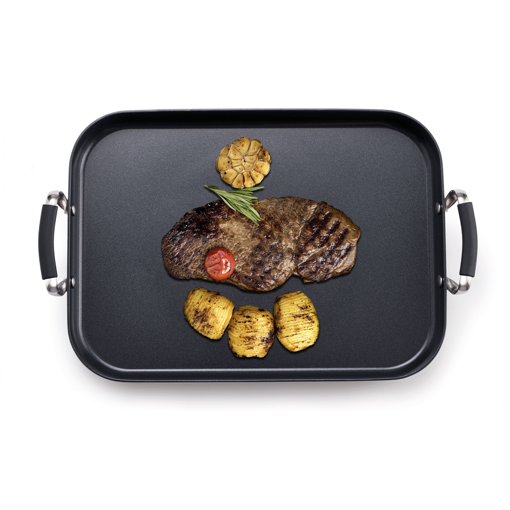 Bistec a la parrilla con tomate, romero y ajo en una plancha negra, acompañado de tres patatas Hasselback.