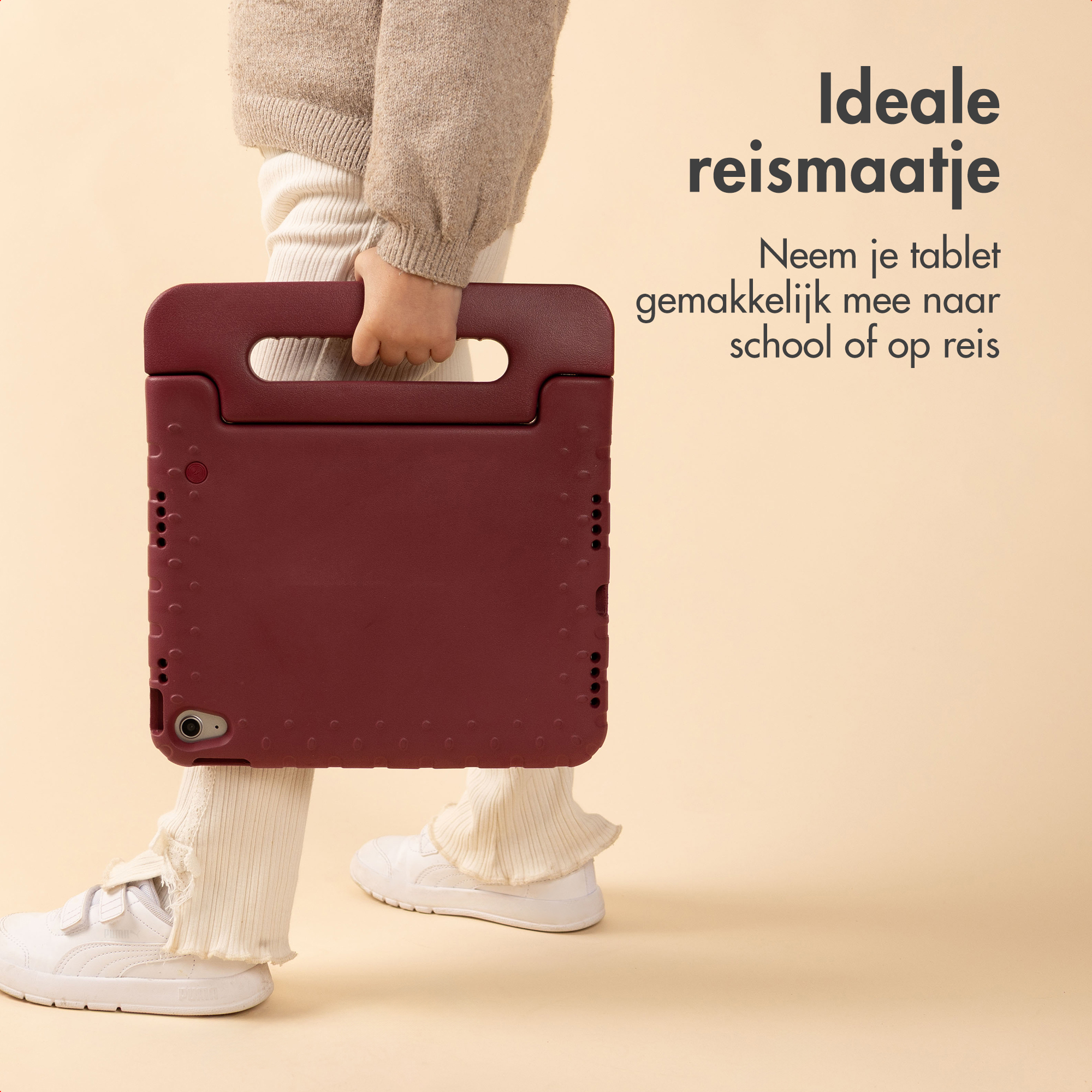 Een kind houdt een bordeauxrode tablethoes vast. Het kind draagt witte schoenen en broek met een beige trui.