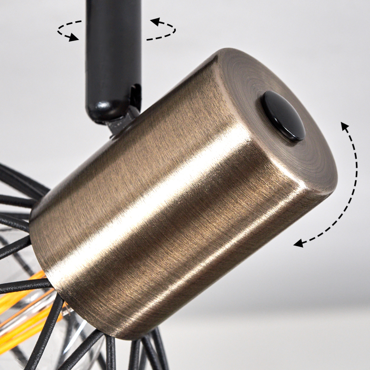 Nahaufnahme einer bronzefarbenen zylindrischen Leuchte mit einem schwarzen Knopf. Sie ist auf einem schwarzen Träger montiert, Pfeile zeigen die Drehung an.