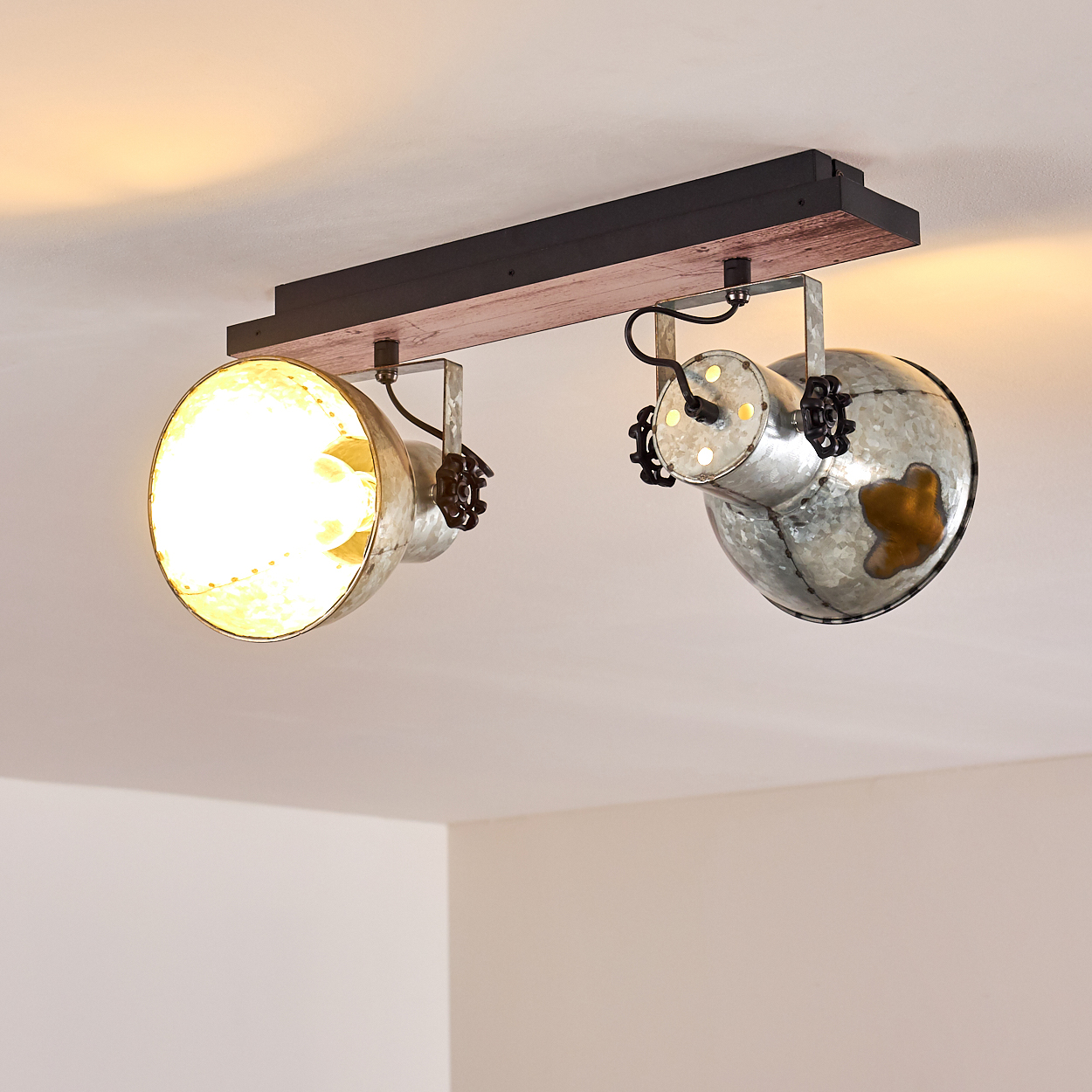 Eine Deckenleuchte mit zwei Scheinwerfern. Die Leuchte hat ein Holz- und Metalldesign und strahlt warmes Licht aus.