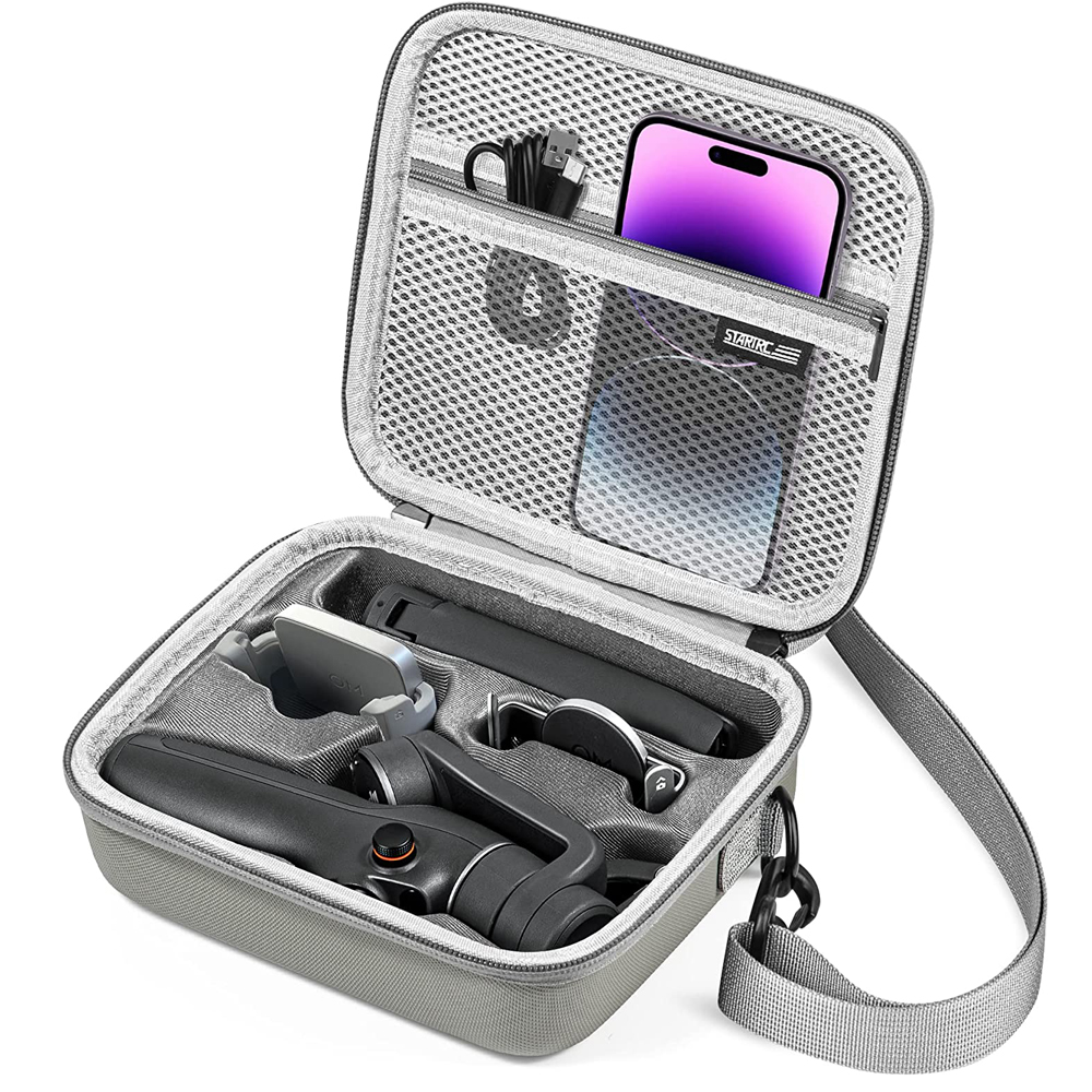 Offene graue Tragetasche mit Telefon, Gimbal und Zubehör. Lila Telefonbildschirm sichtbar. Koffer hat Schultergurt und Netztasche.