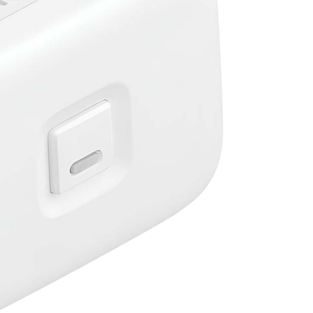 Primo piano di un dispositivo bianco con un pulsante rettangolare. Il pulsante è bianco con un'indentazione grigia curva.