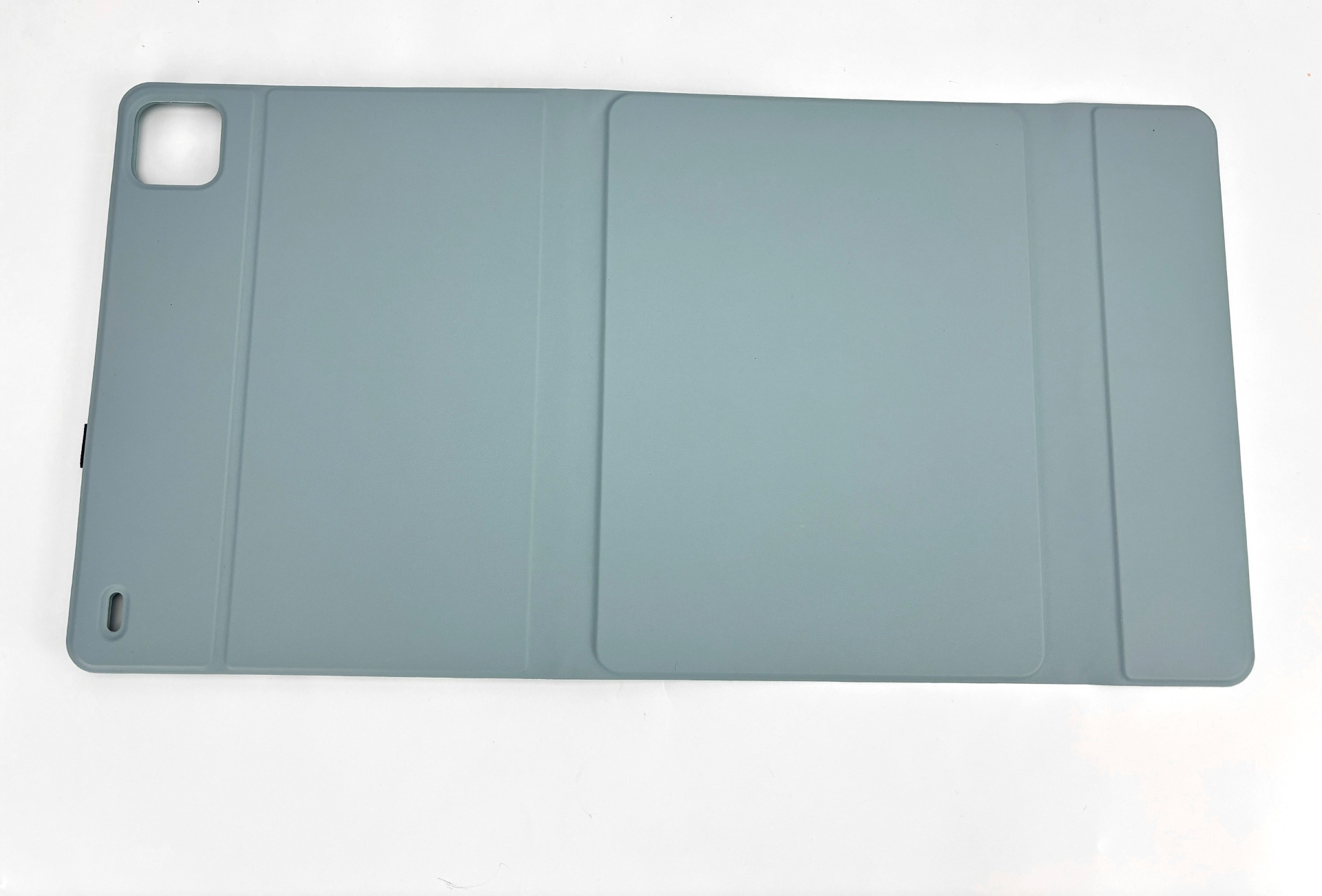 Eine hellblaue Tablethülle liegt auf einer weißen Oberfläche. Die Hülle ist rechteckig mit einem Kameraausschnitt und einem kleinen Anschluss.