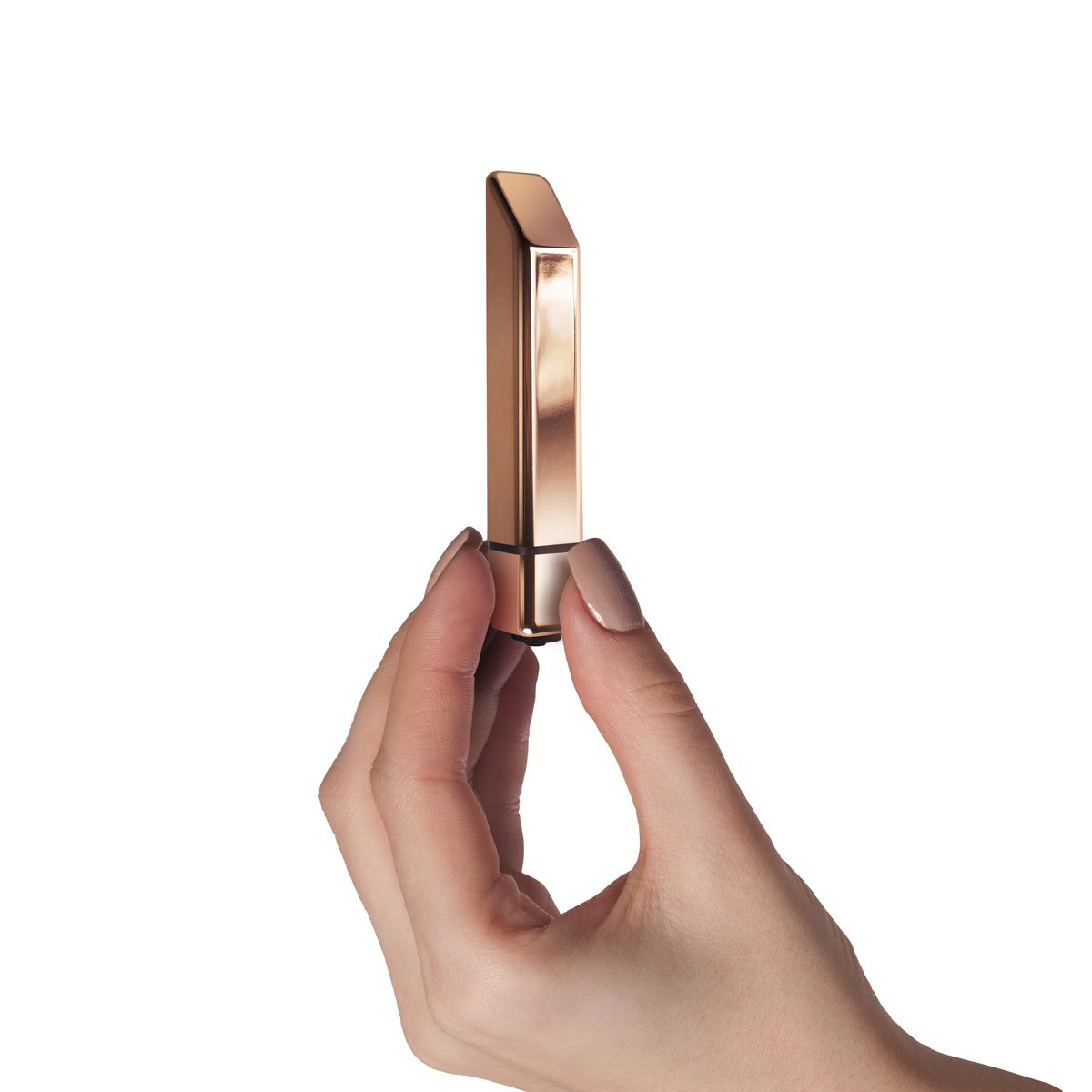 Eine Hand hält einen goldenen Lippenstift vor weißem Hintergrund. Der Lippenstift ist rechteckig mit schräger Oberseite.