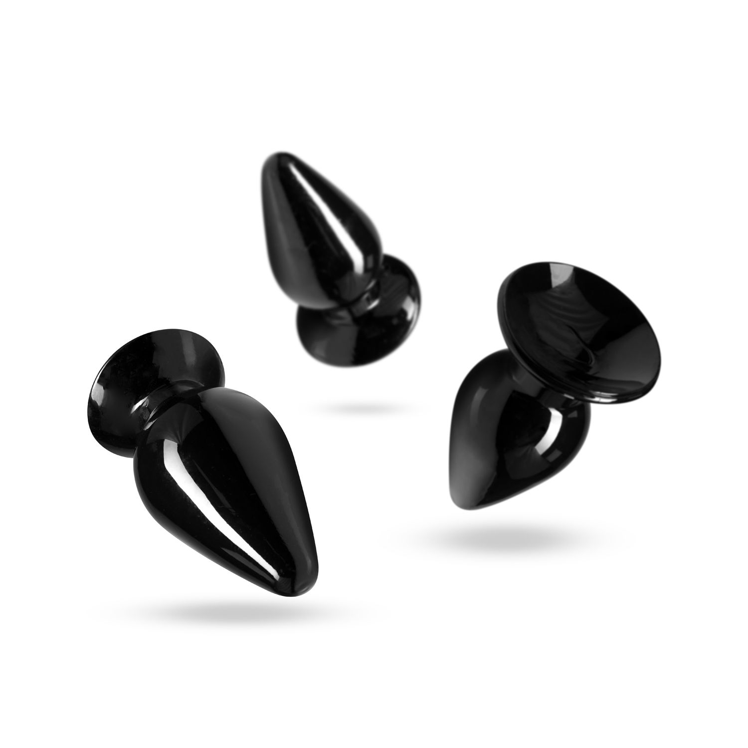Drei glänzende, schwarze Anus-Stecker schweben vor einem weißen Hintergrund. Jeder hat eine bauchige Basis und einen sich verjüngenden, glatten Körper.