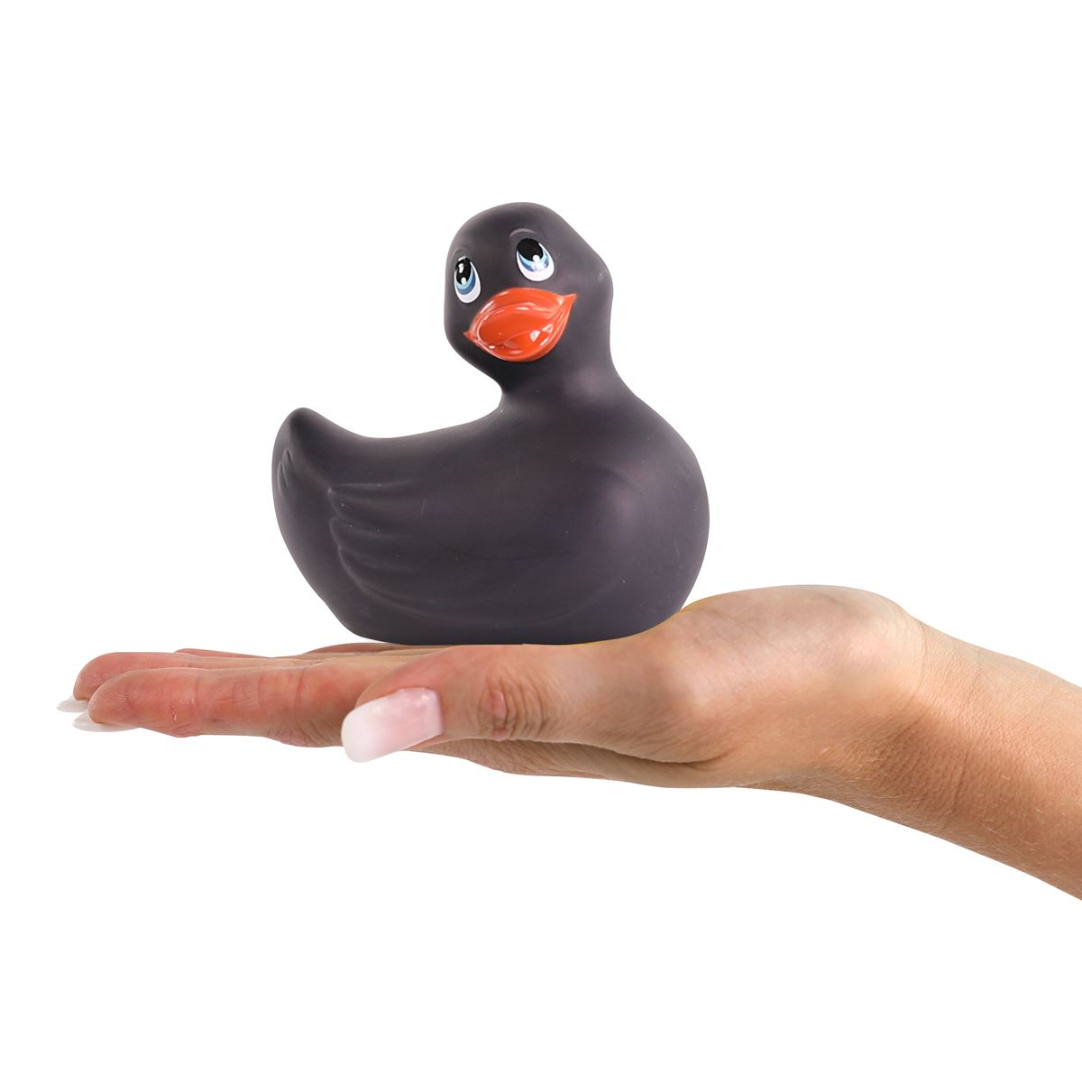 Eine Hand hält eine schwarze Gummiente mit blauen Augen und einem orangefarbenen Schnabel. Der Hintergrund ist weiß.