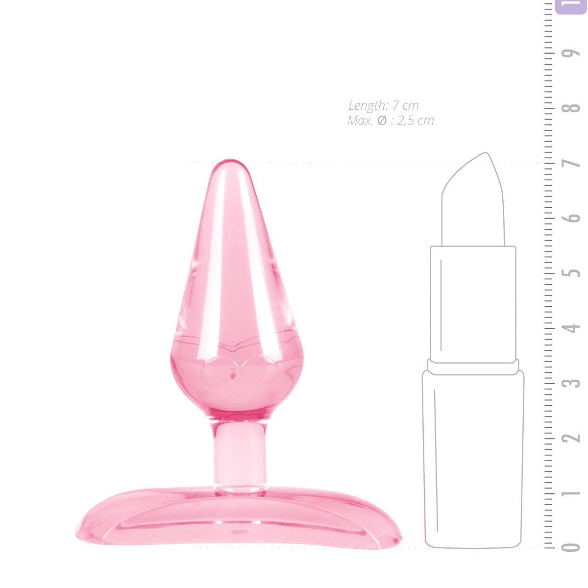 Ein rosafarbener, durchsichtiger Analplug neben einer Lippenstiftkontur, beides auf weißem Grund mit Lineal.