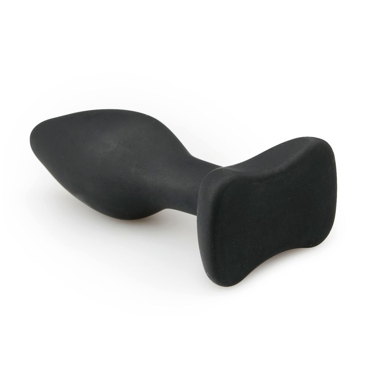 Ein schwarzer Analsex-Plug liegt auf einer weißen Oberfläche. Er hat einen abgerundeten, sich verjüngenden Körper und einen flachen, gebogenen Sockel.