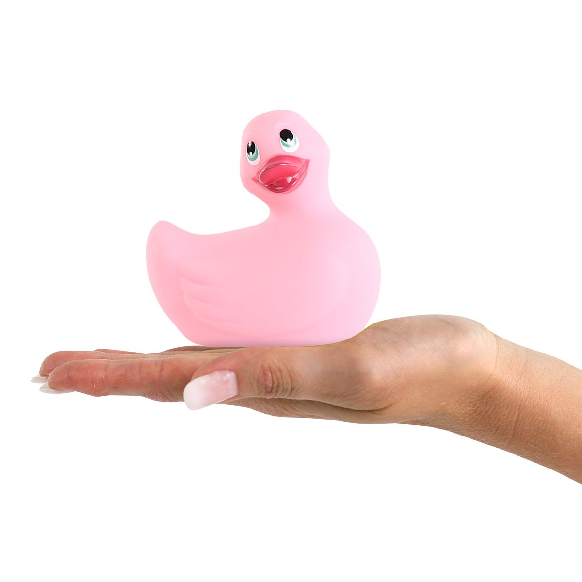 Eine rosa Gummiente wird in der Handfläche gehalten. Die Ente hat einen roten Schnabel und schwarze Augen. Die Nägel sind manikürt.